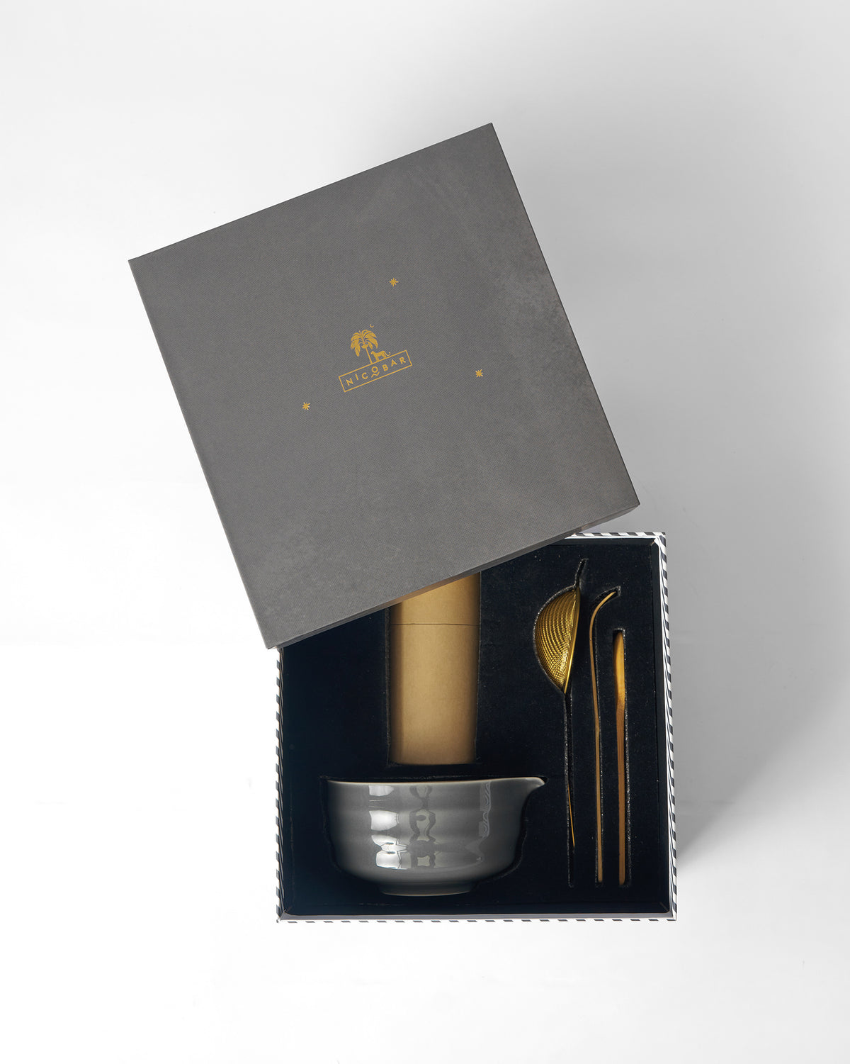 Open Matcha gift box showing a grey spouted bowl, canister, and gold utensils.