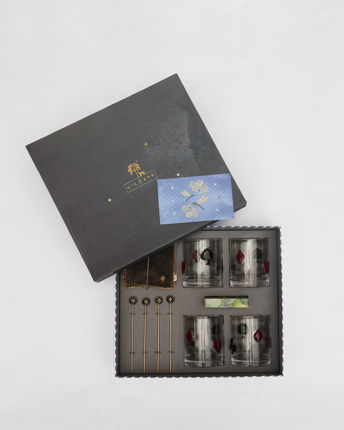 Mehfil bar gift set unpacked with whiskey glasses and gold stirrers.