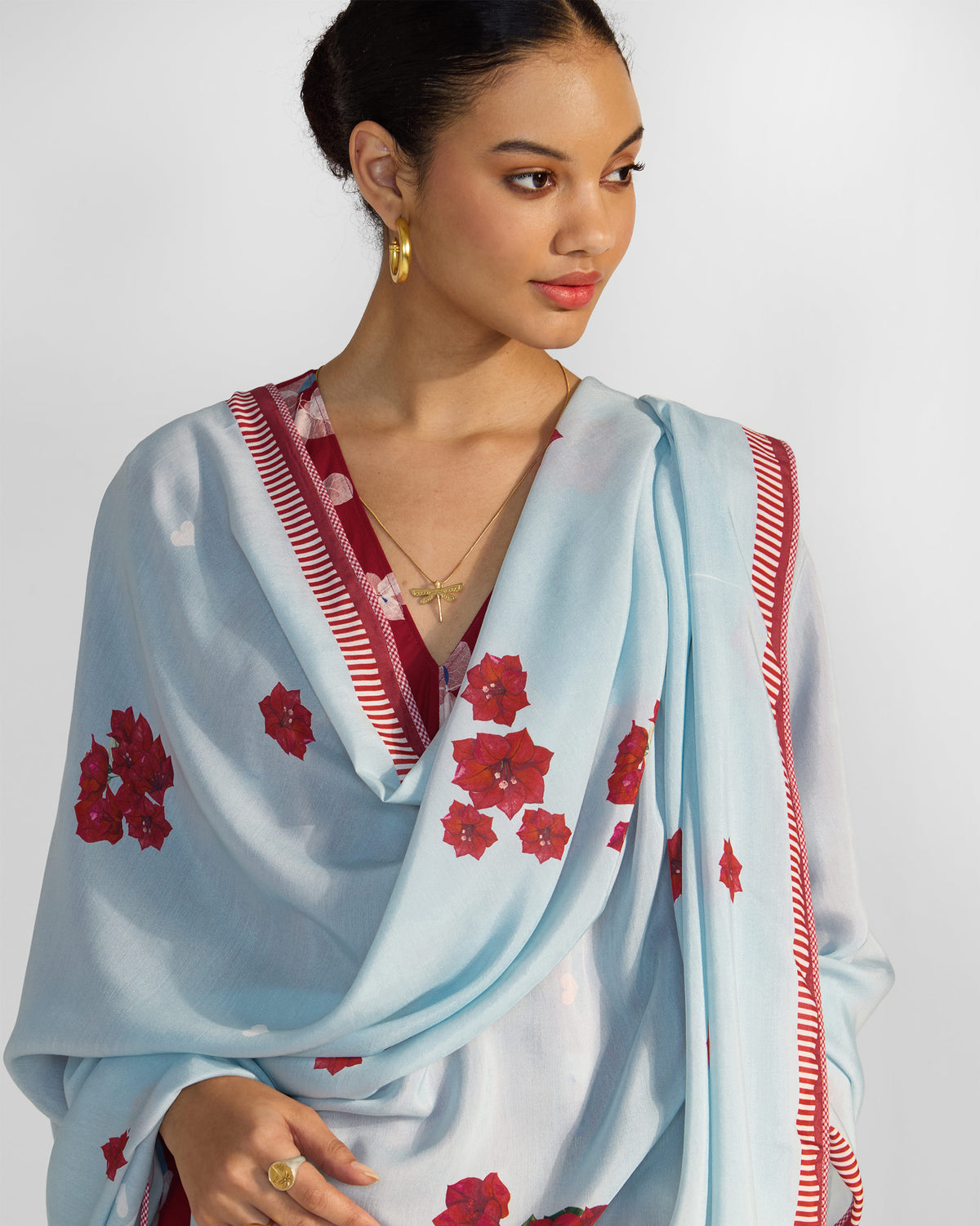 Person wearing an ice blue Inara Dupatta with red floral prints.