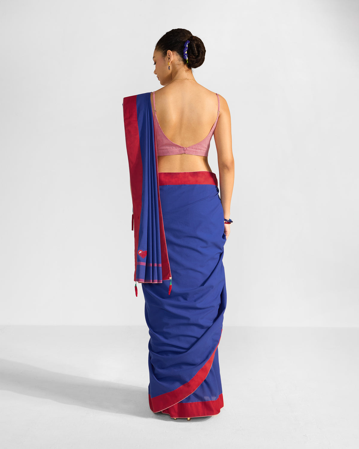 Back of a navy and red Noor sari worn by a person.
