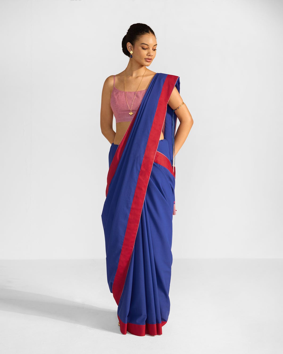 Person wearing a navy and red Noor sari draped over one shoulder.