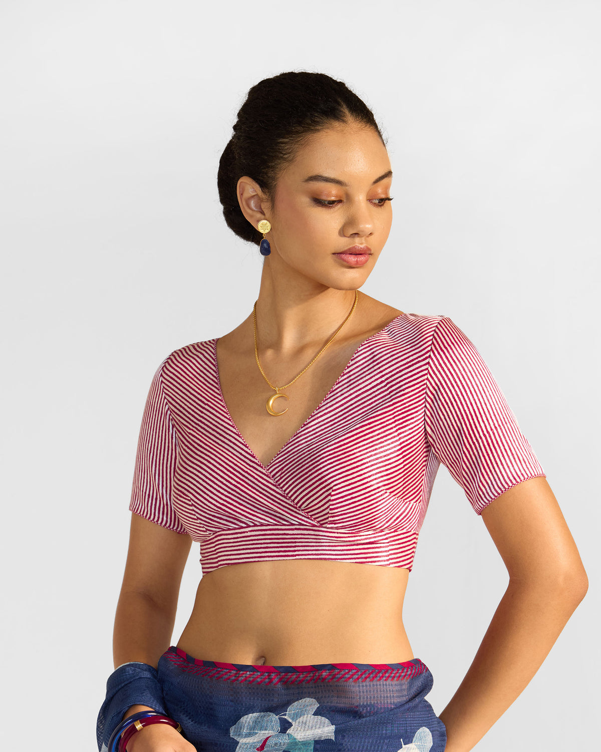 Person wearing a red and white striped Zahra Blouse with a wrap V-neck.