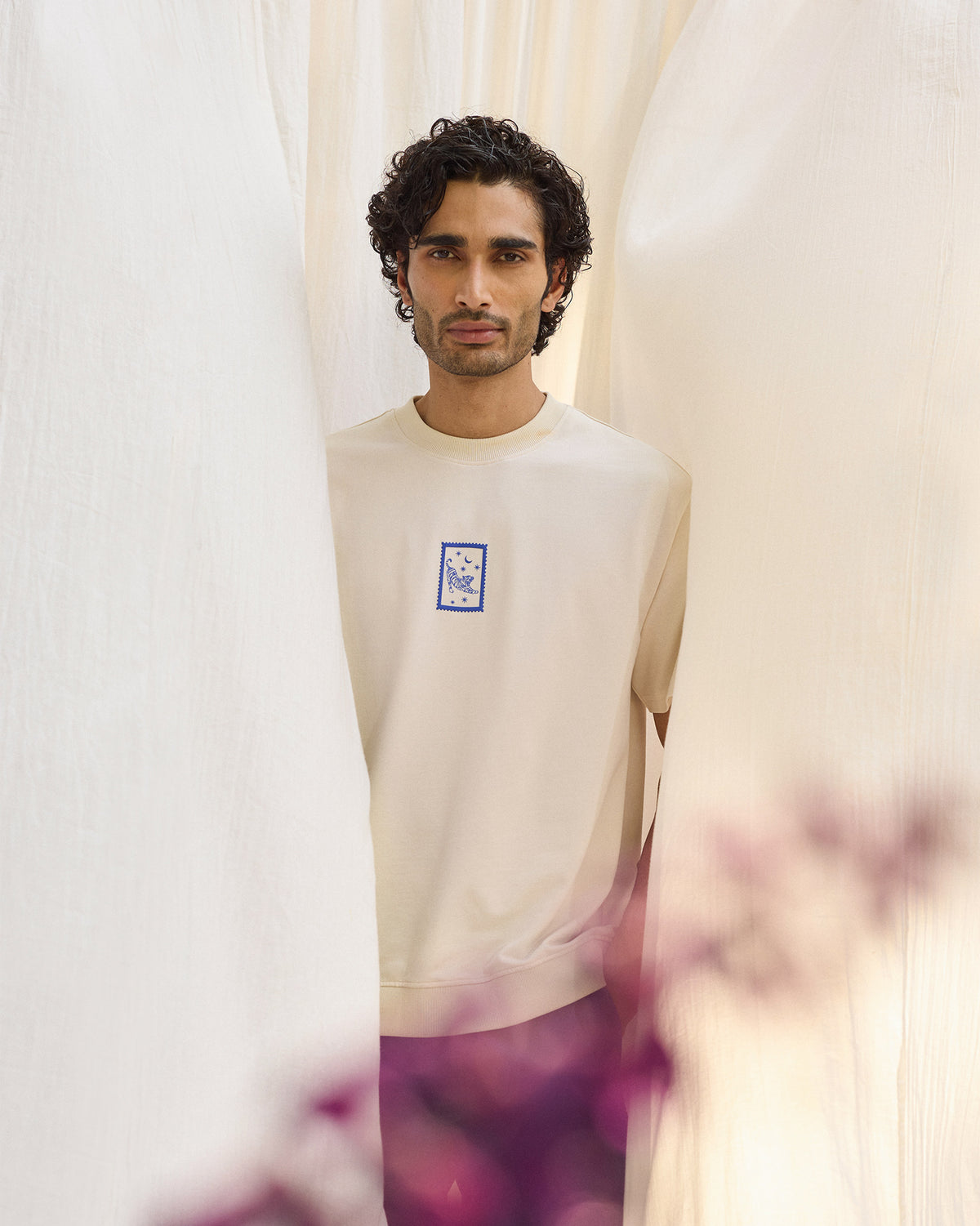Person wearing an ivory leaping tiger t-shirt with a blue chest stamp print.