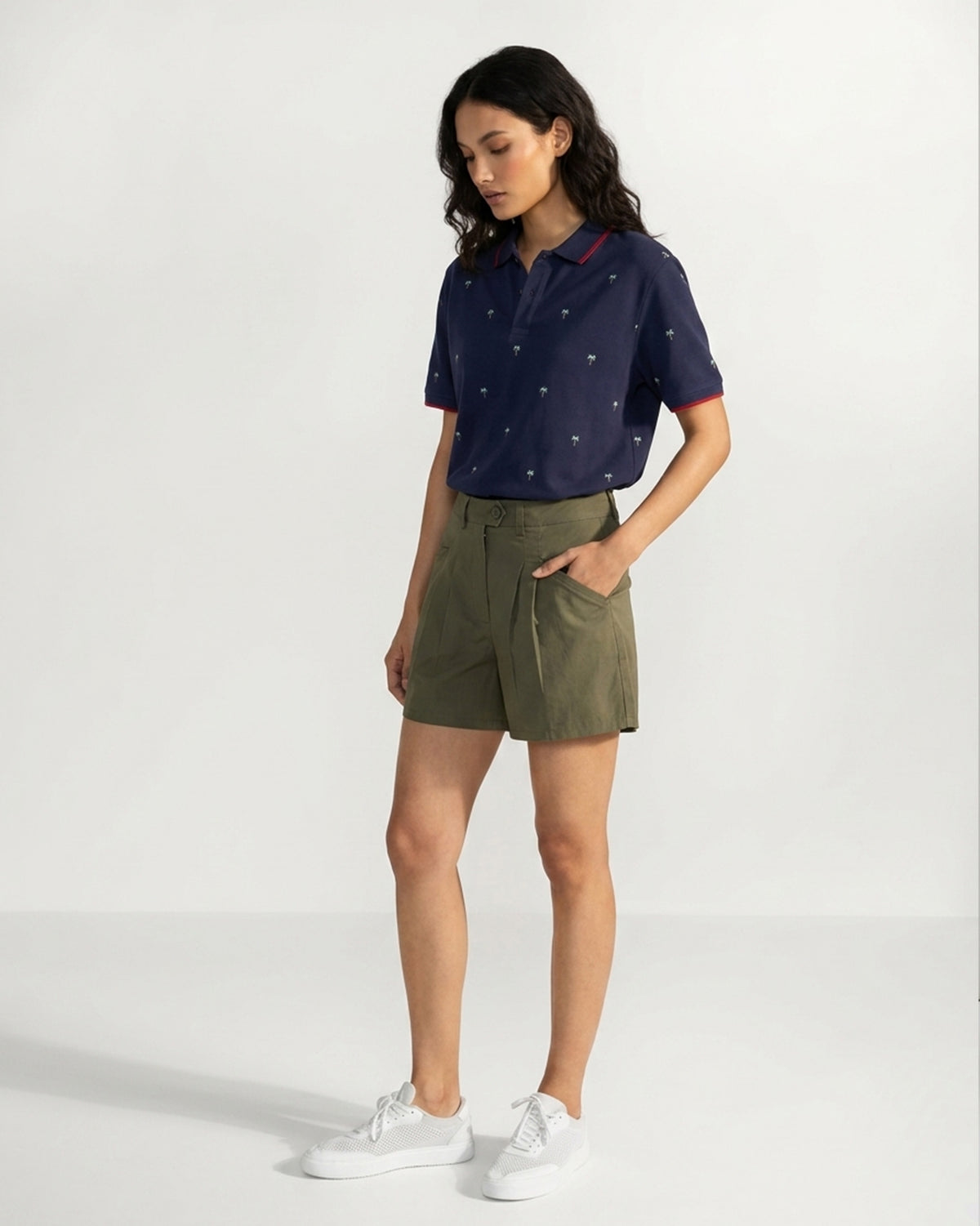 Side view of an ink blue Palma polo with a palm tree print worn by a person.