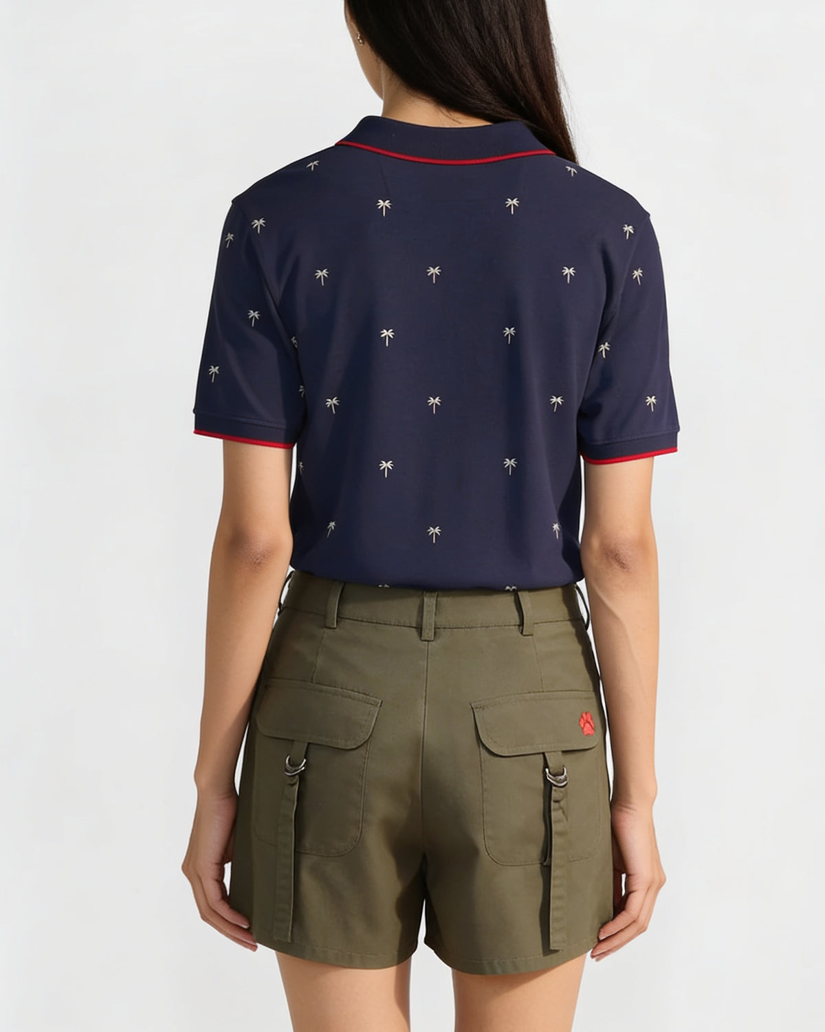 Back of an ink blue Palma polo with a palm tree print worn by a person.