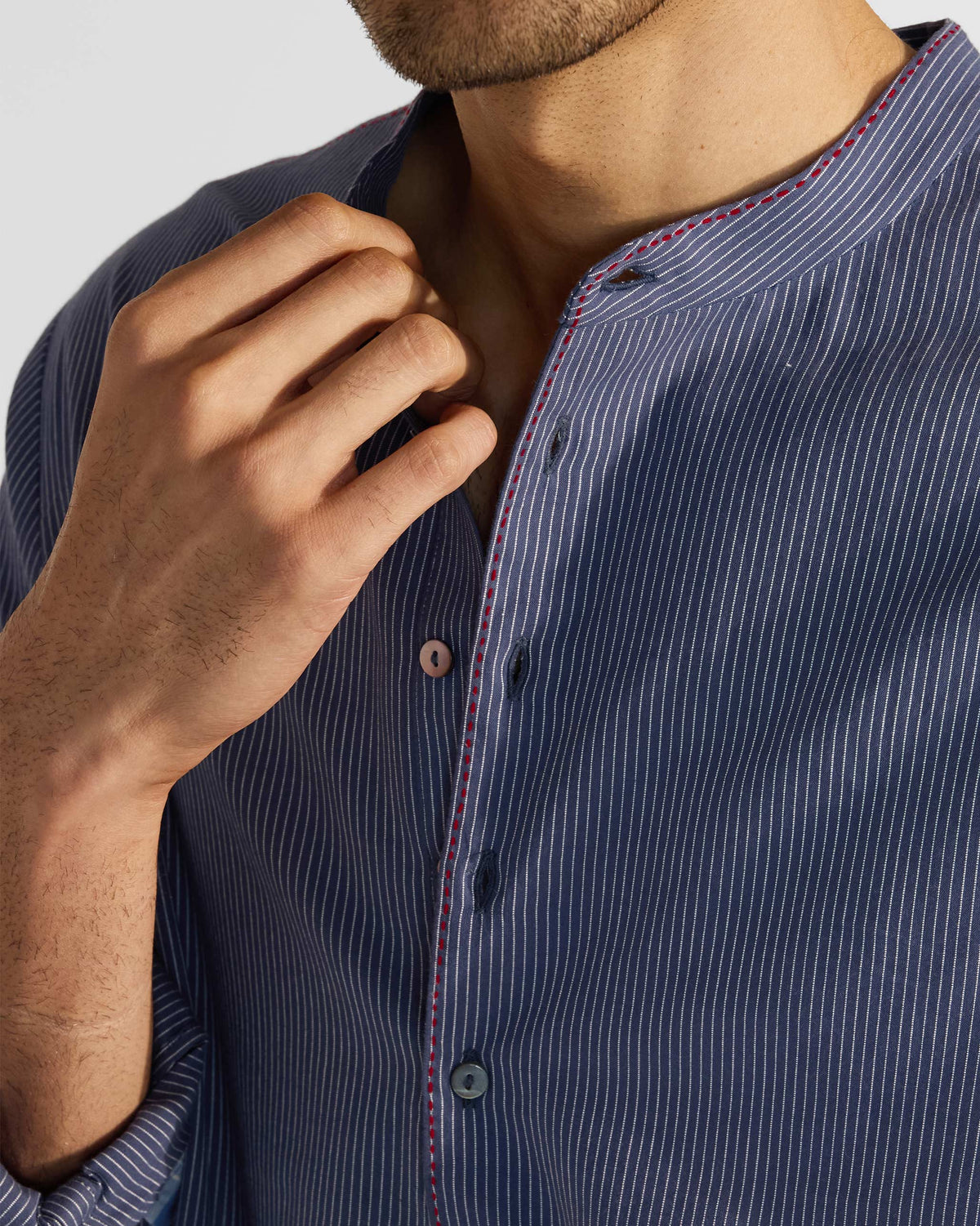 Close-up of a navy striped Nysa Kurta band collar with red contrast stitching.