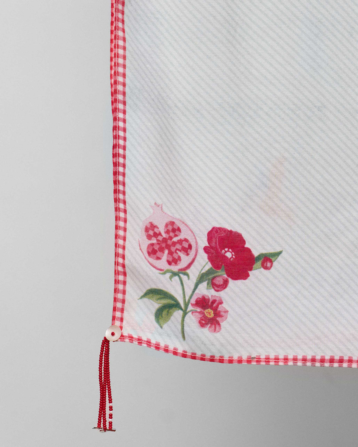 Close-up of a Floral Bloom scarf corner showing a pomegranate and red flowers.