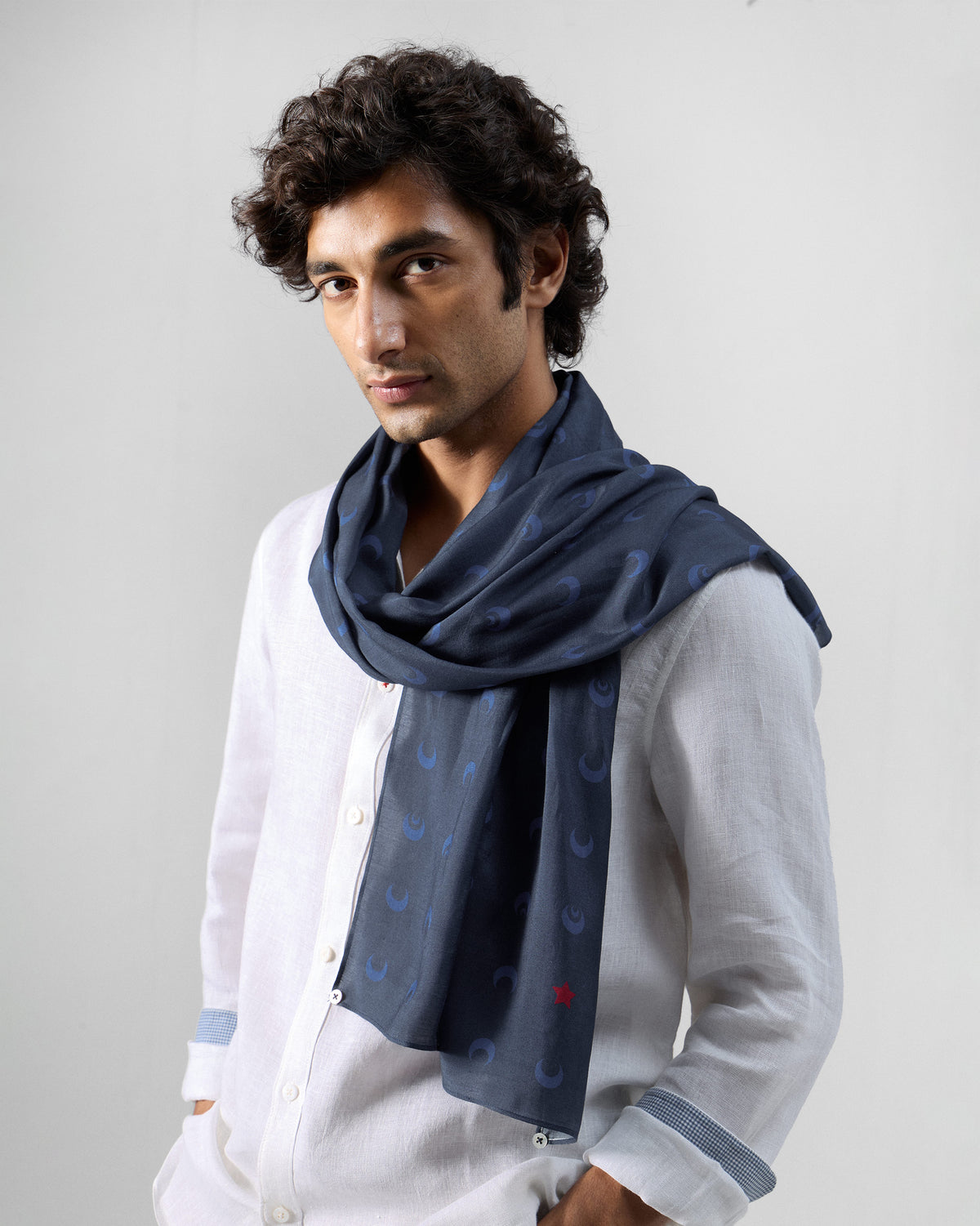 Person wearing a navy Moonlit scarf with a crescent moon print.
