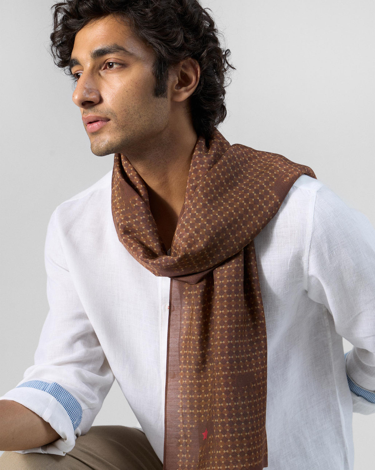 Person wearing a brown Heera scarf with a small dotted pattern.