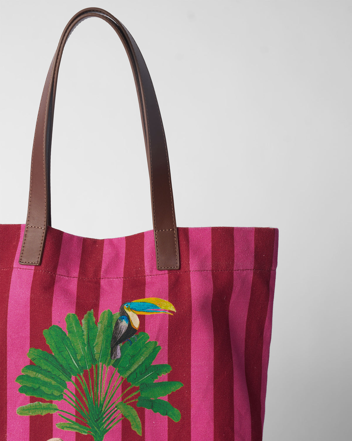 Close-up of a Mukayu city tote showing a toucan on a palm leaf.