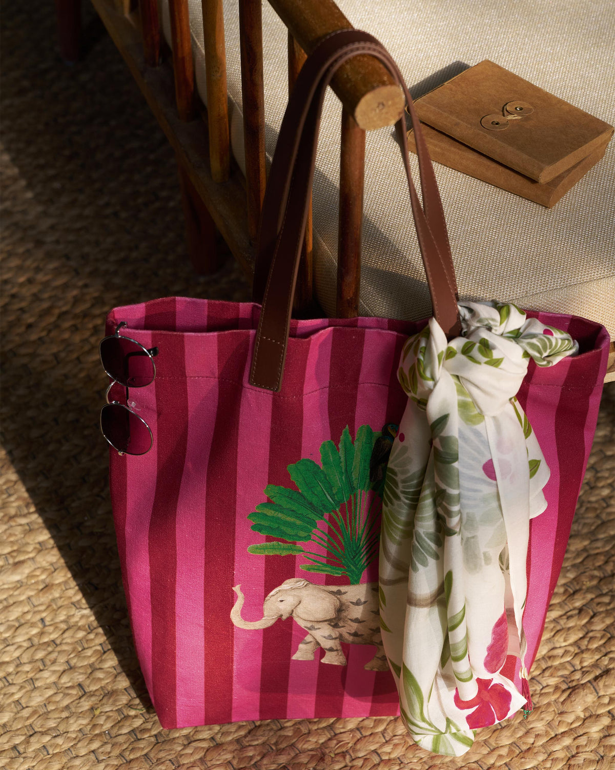 Pink and maroon Mukayu city tote with an elephant print hanging from a chair.