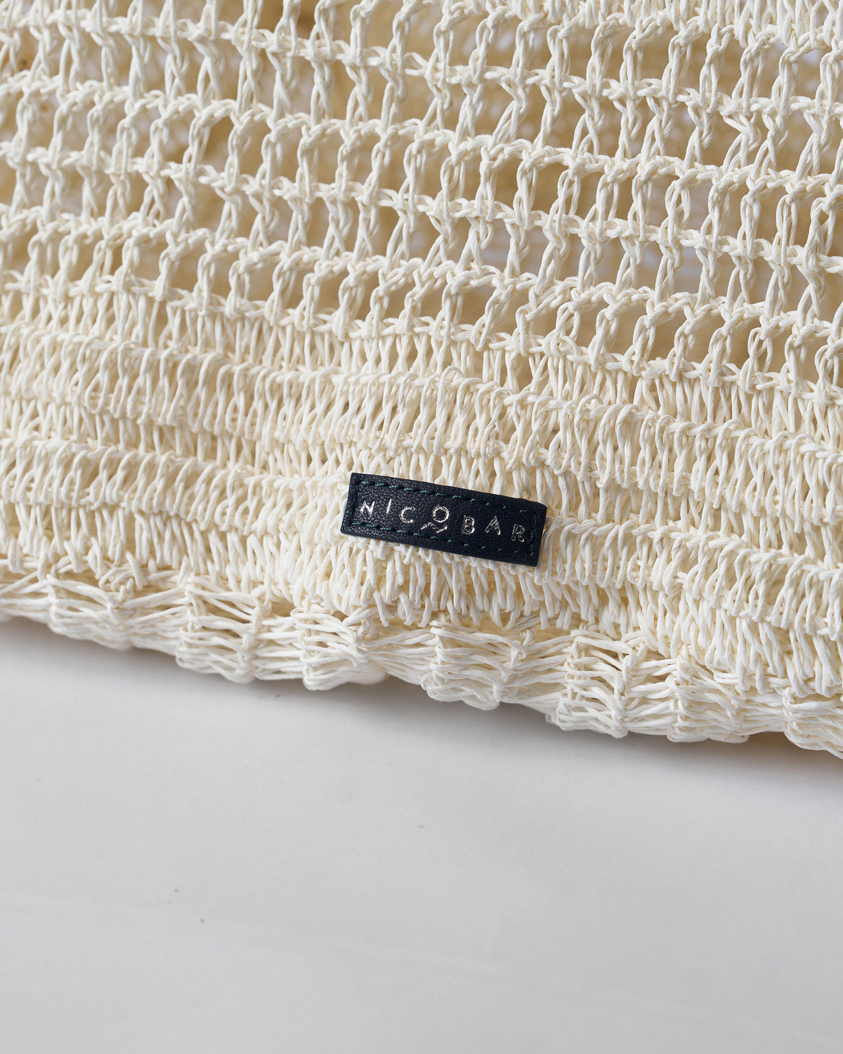 Close-up of the cream open-weave fabric with a Nicobar label.