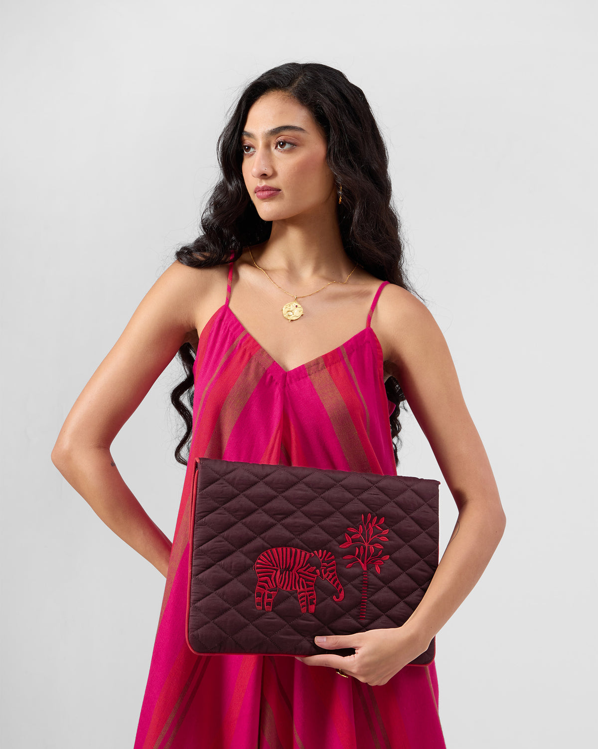 Brown Ele laptop sleeve with red elephant embroidery held in hands.