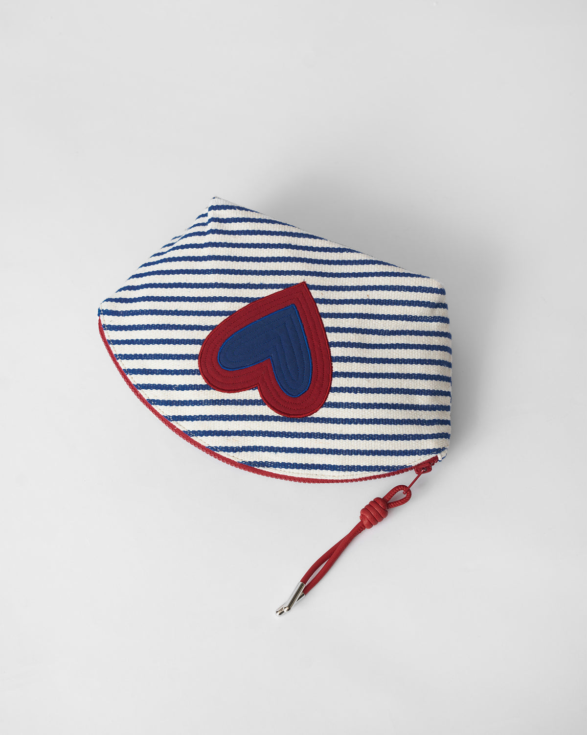 Blue and white Kira Pouch with a red heart and red zipper.