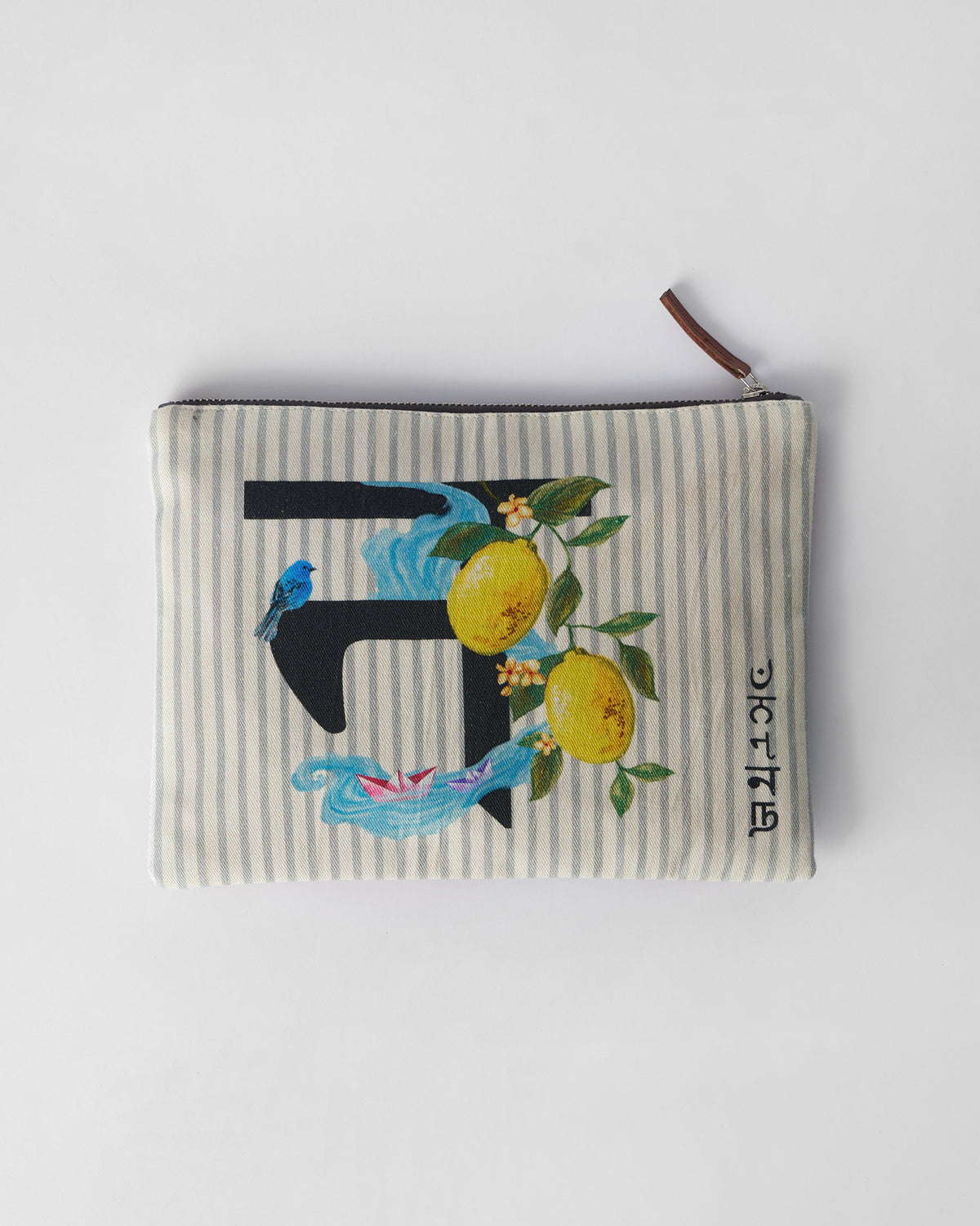 Ivory Nilambari Pouch with a black letter print, lemons, and paper boats.