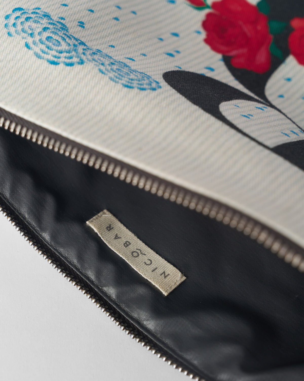 Open ivory Rimjhim Pouch showing the dark lining and Nicobar label.