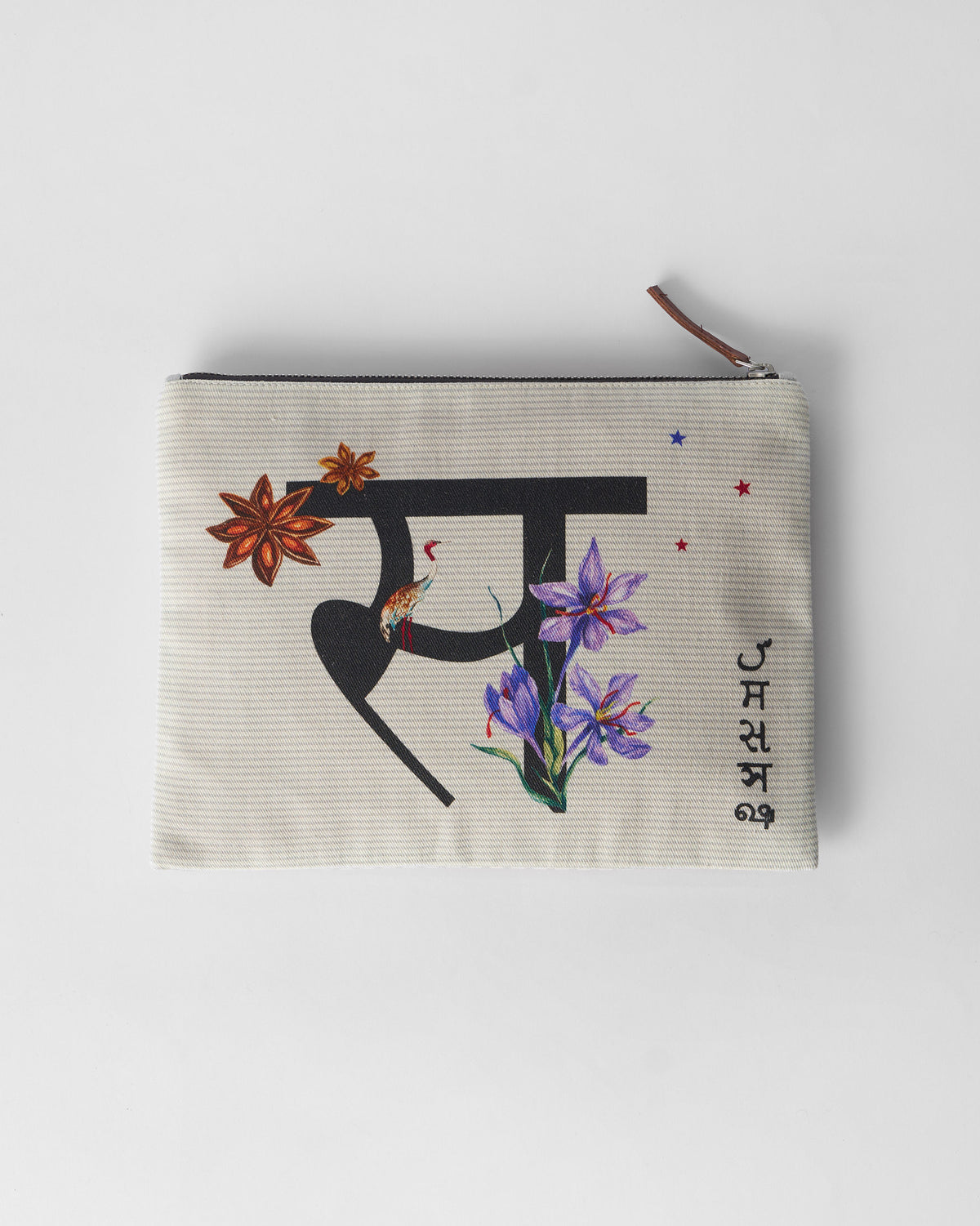 Ivory Sitara Pouch with a black Devanagari letter, star anise, and purple flowers.
