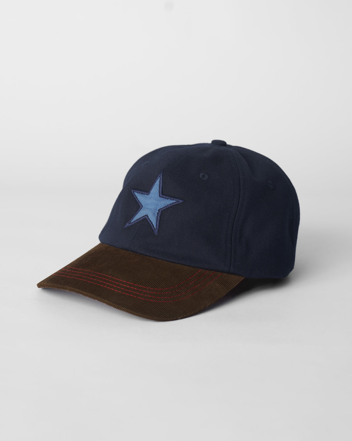 Navy Starry Cap with a light blue star and brown corduroy brim.