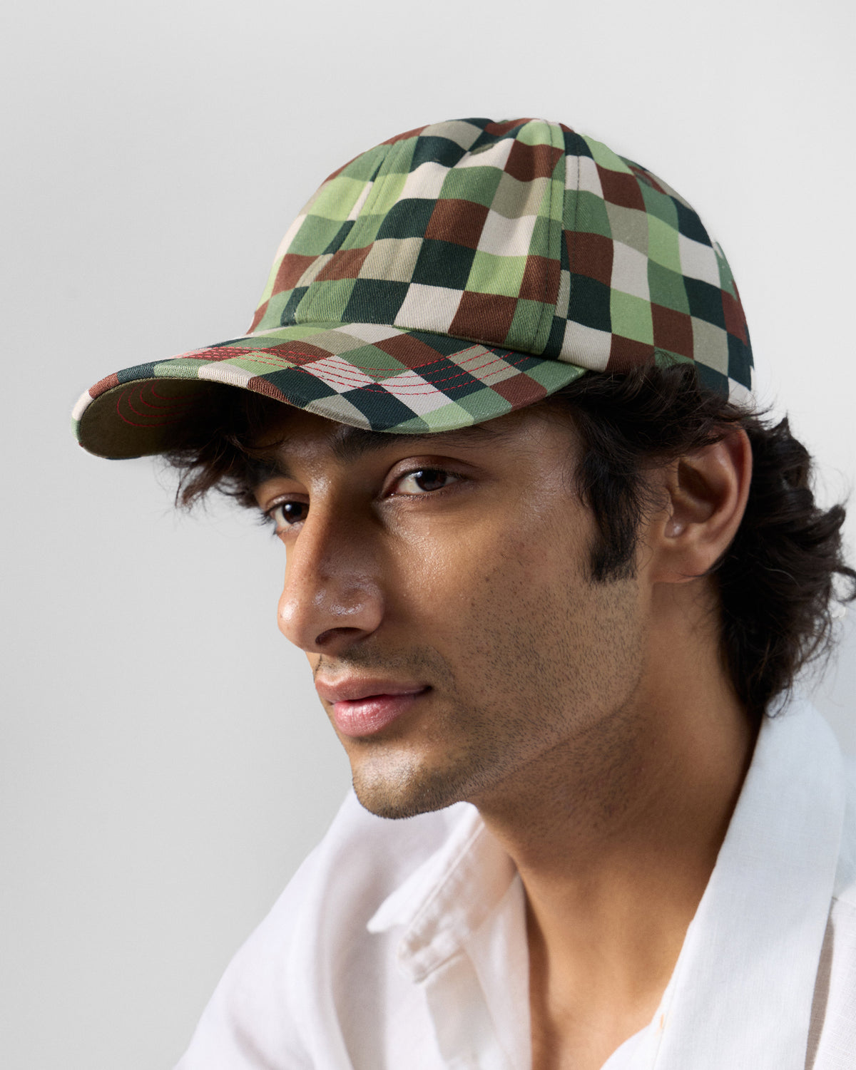 Person wearing an olive pixel-print baseball cap with a curved brim.