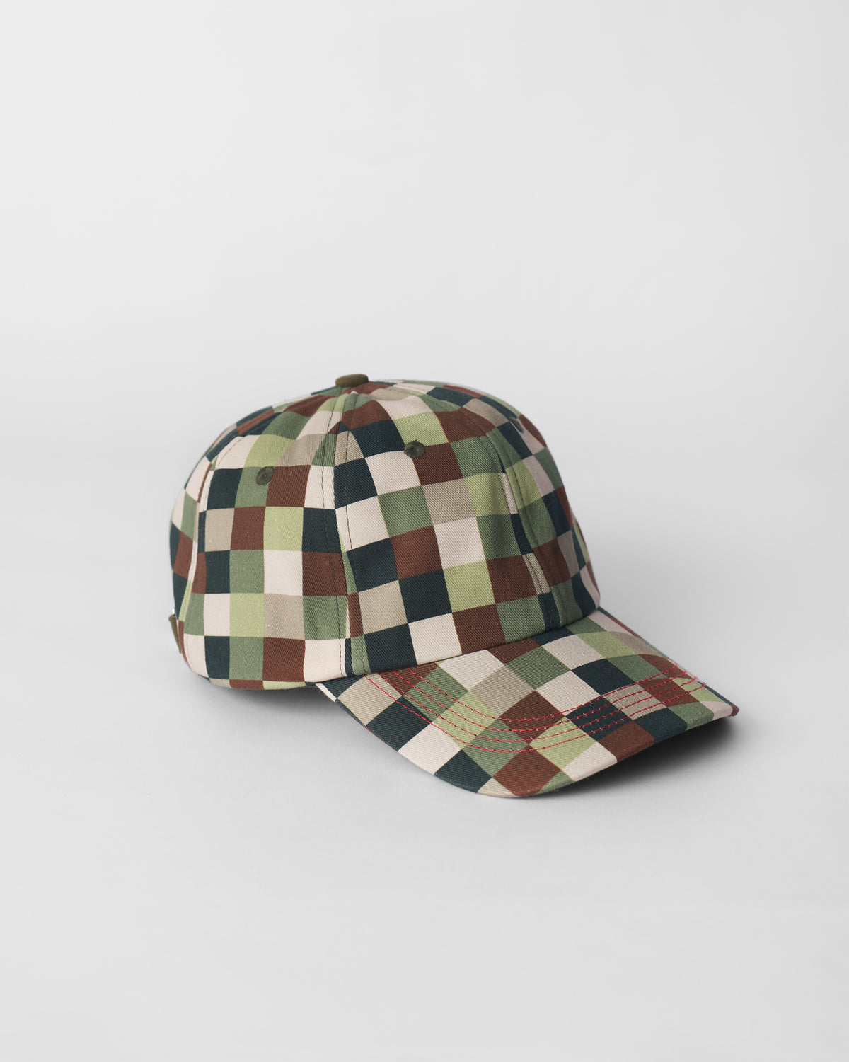 Olive pixel-print cap showing six-panel crown, eyelets, and red brim stitching.
