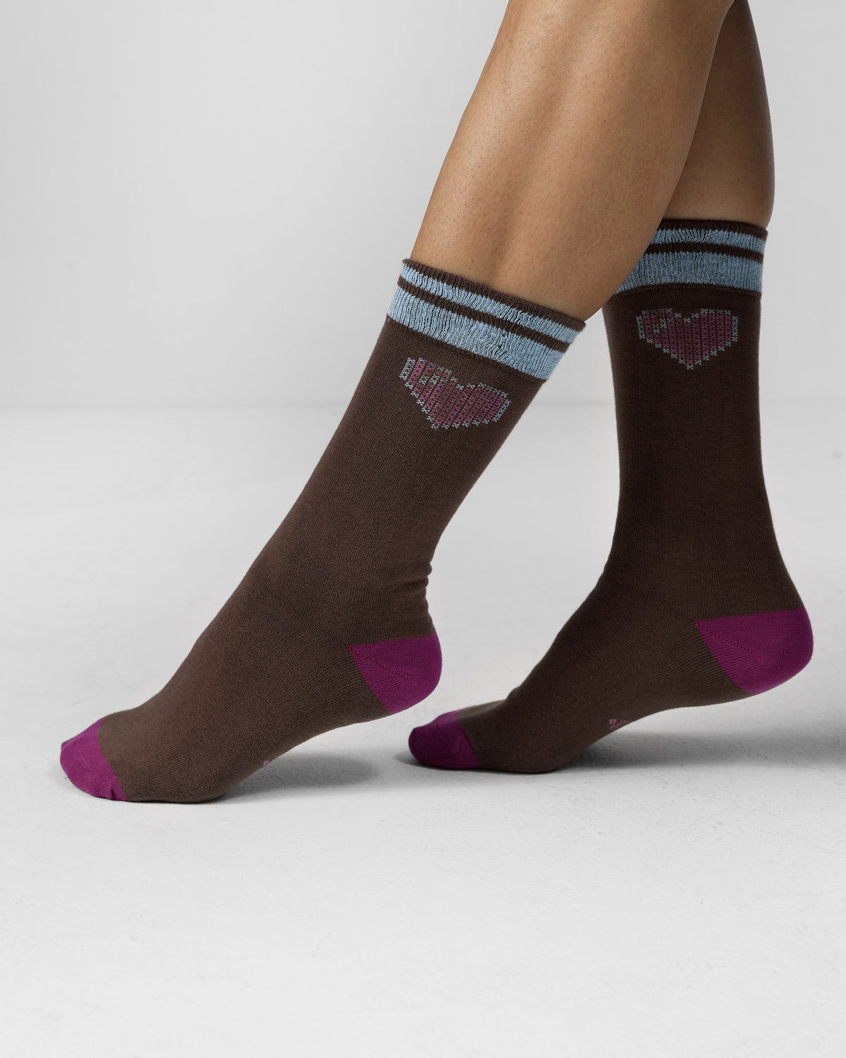 Person wearing brown Pixel Heart Socks with fuchsia heels and pixel hearts.
