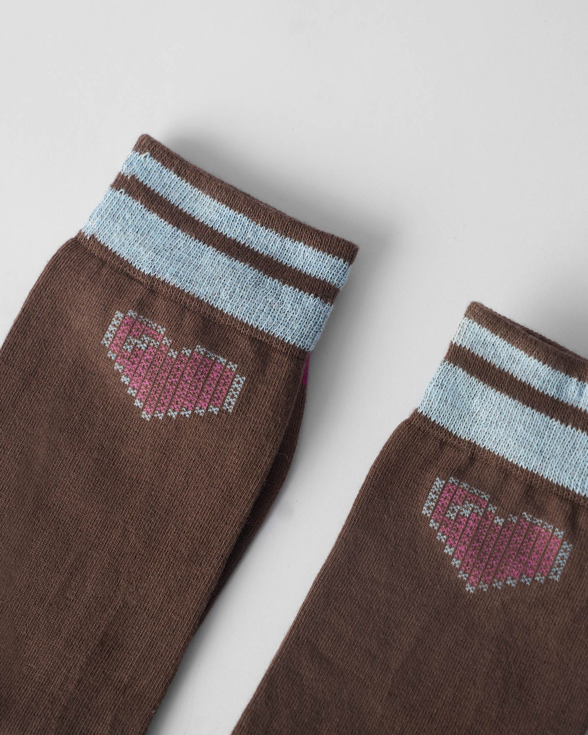 Close-up of pink pixel hearts on brown Pixel Heart Socks.