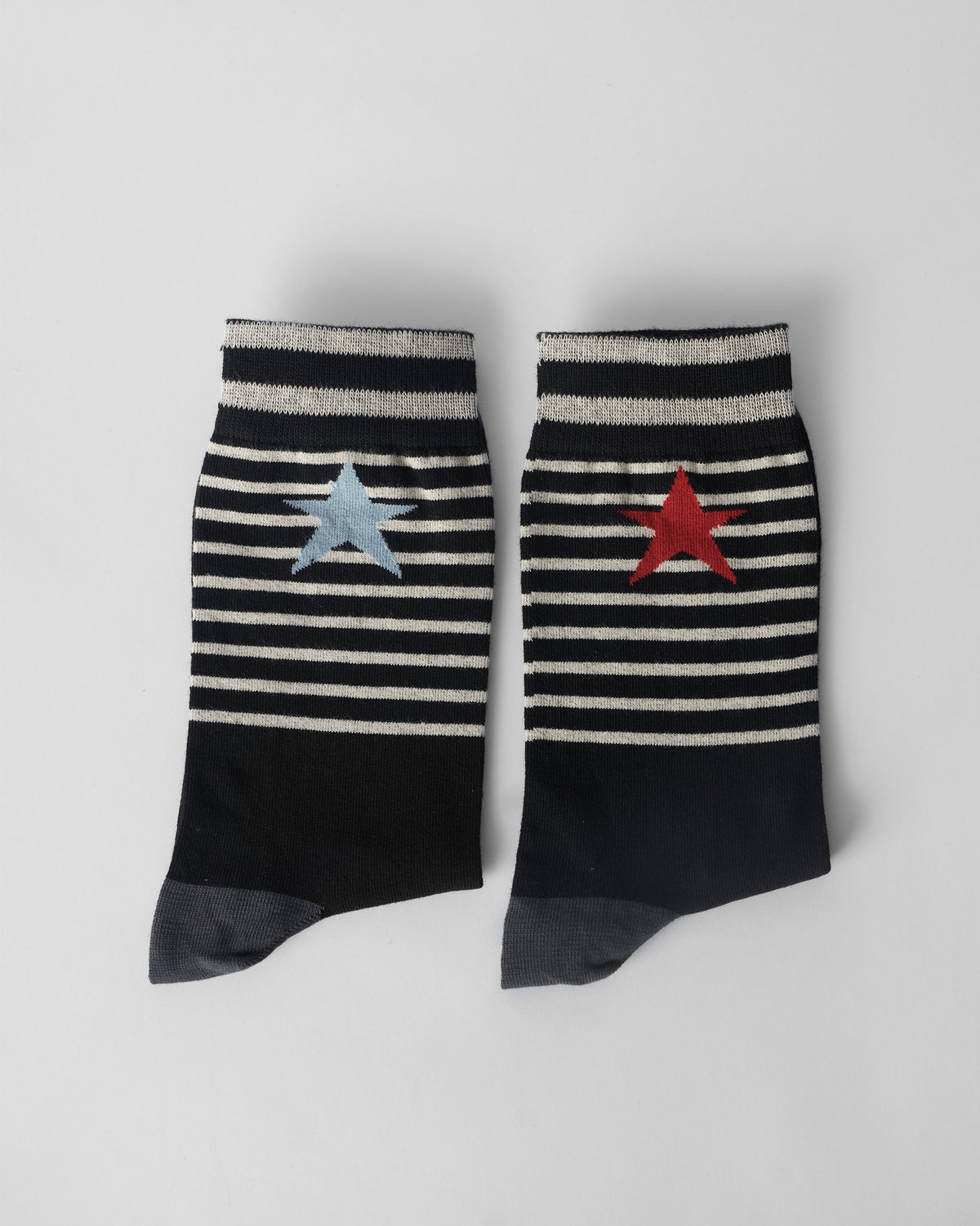 Pair of black Starfly socks laid flat with striped cuffs and star motifs.