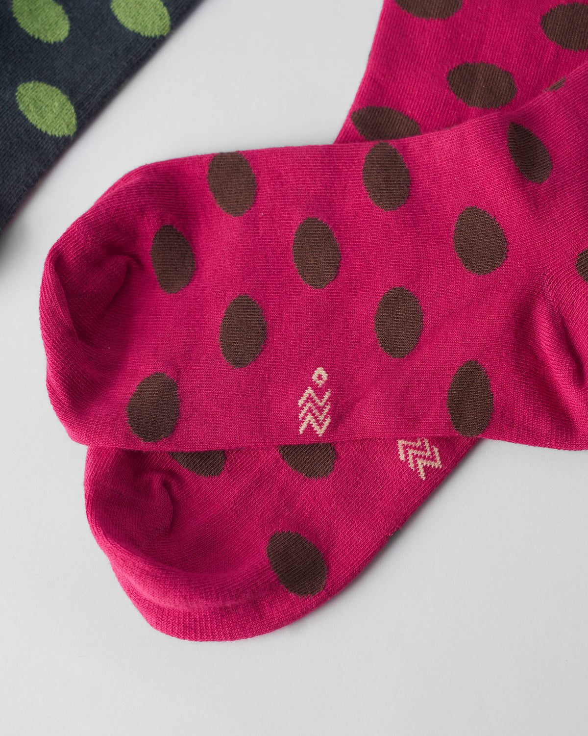 Close-up of fuchsia Polka Love socks with brown polka dots.