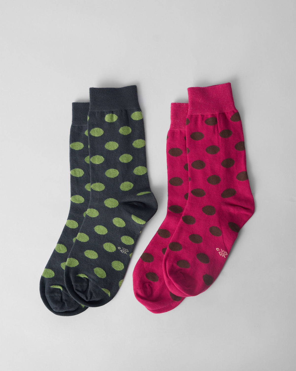 Fuchsia and charcoal Polka Love socks with polka dots laid flat.