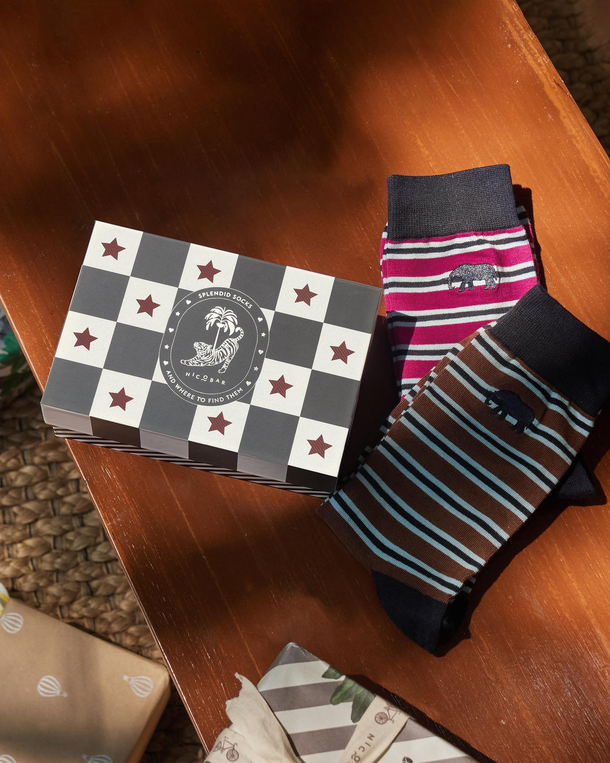 Stripey Socks gift set with mulberry and brown pairs beside the Nicobar box on wood.