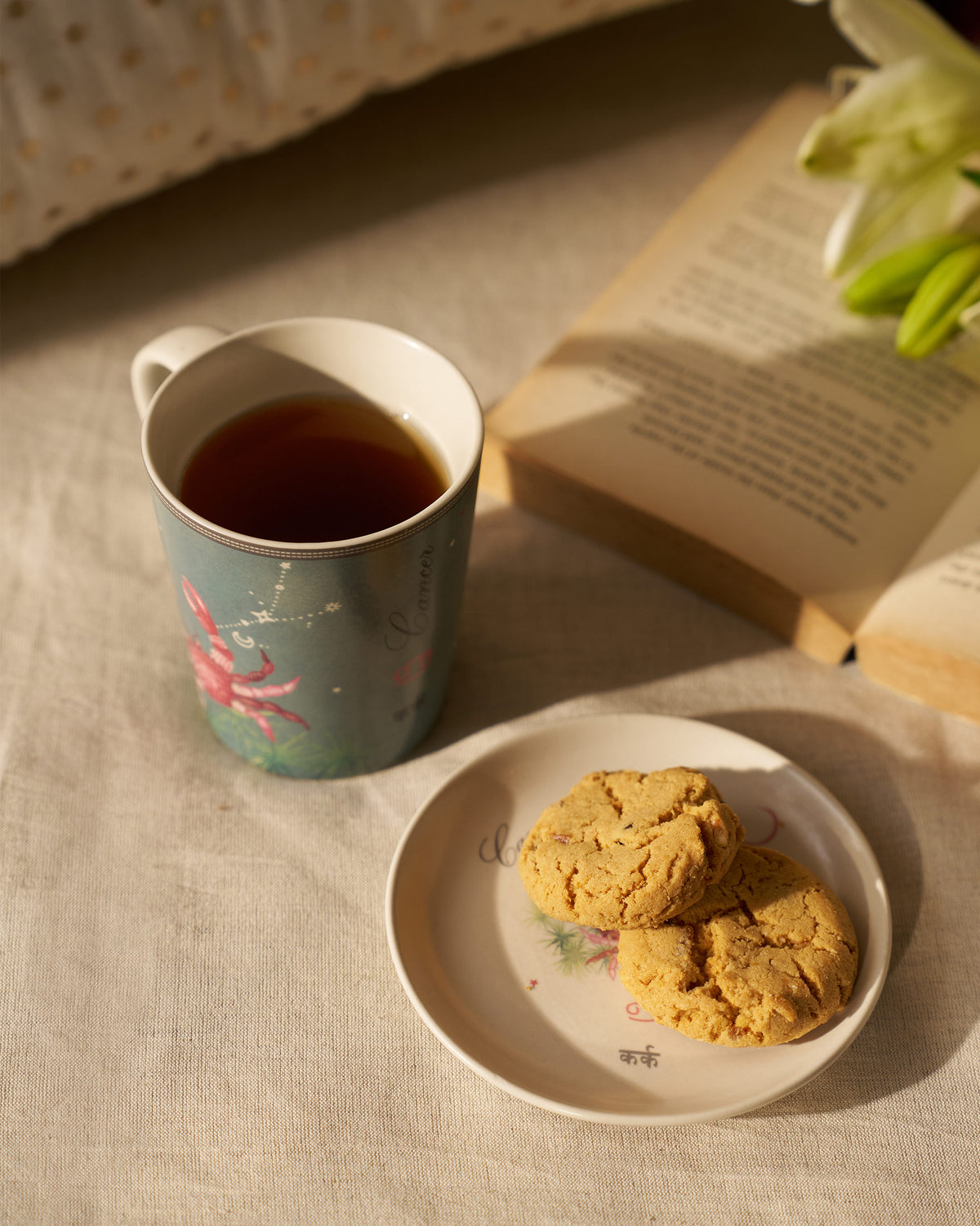 Nico Cancer mug and plate used for tea with cookies.