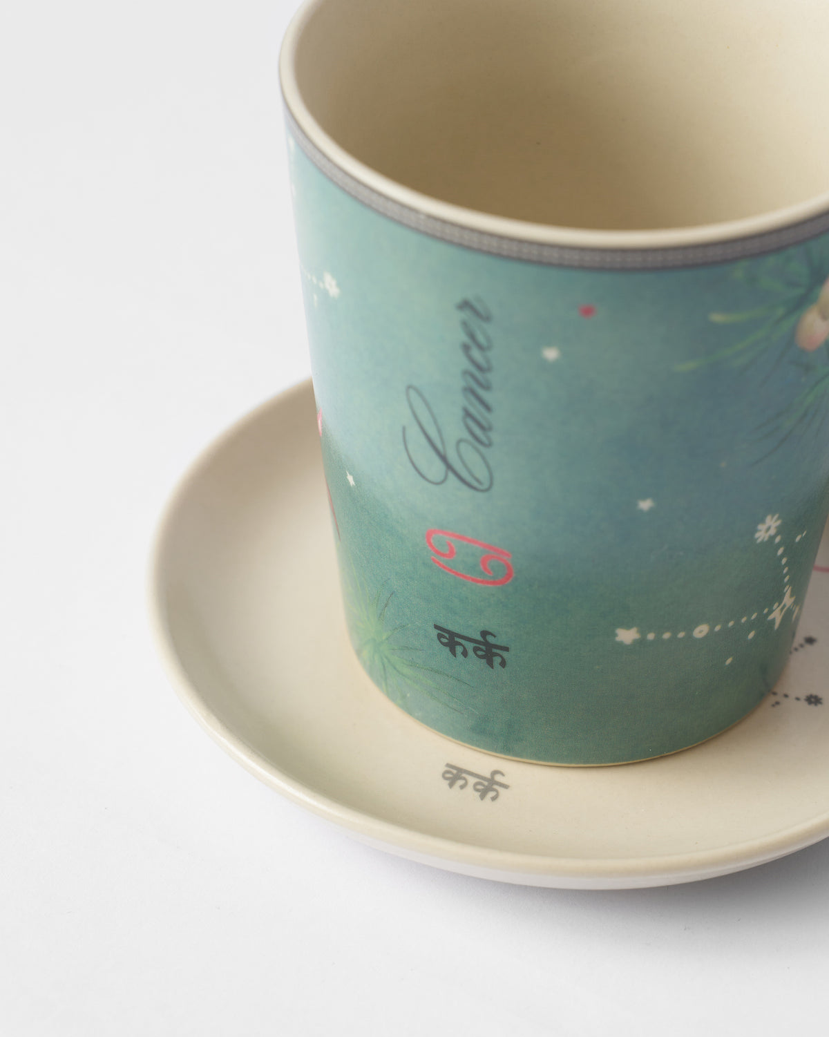 Close-up of Nico Cancer mug and plate with कर्क lettering.