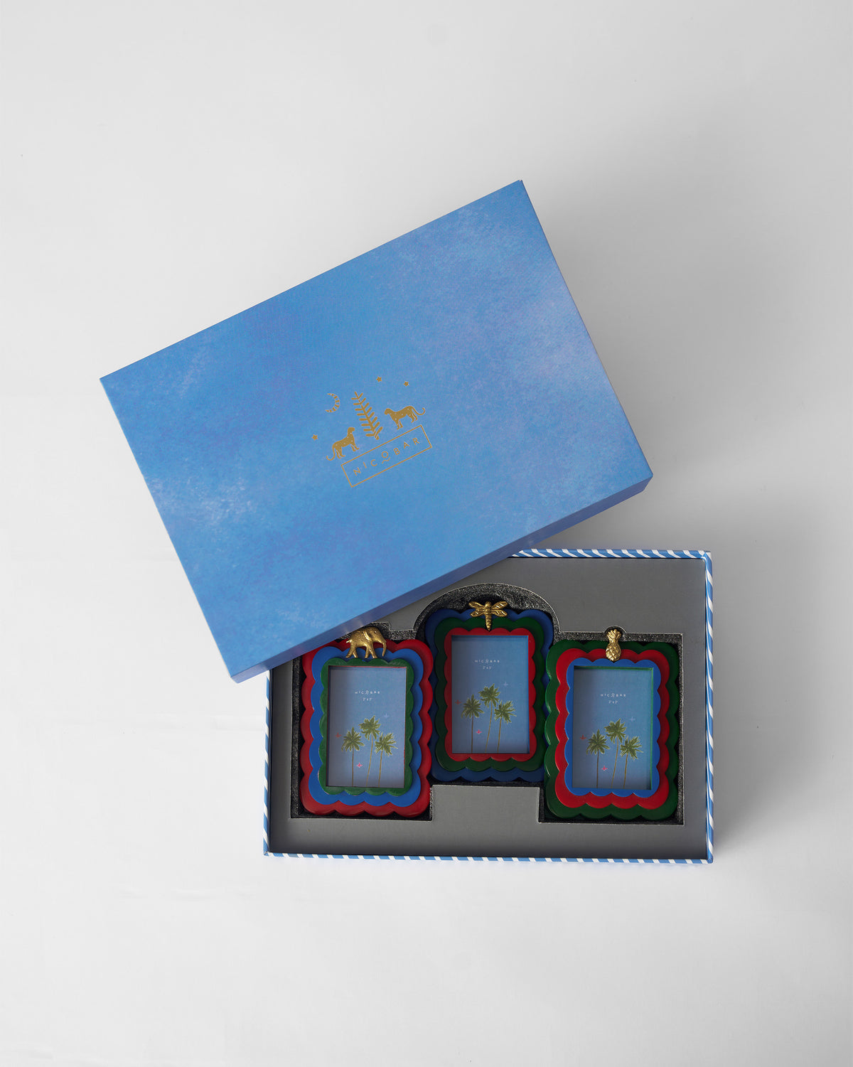 Tropics photo frames packed in an open blue Nicobar gift box.