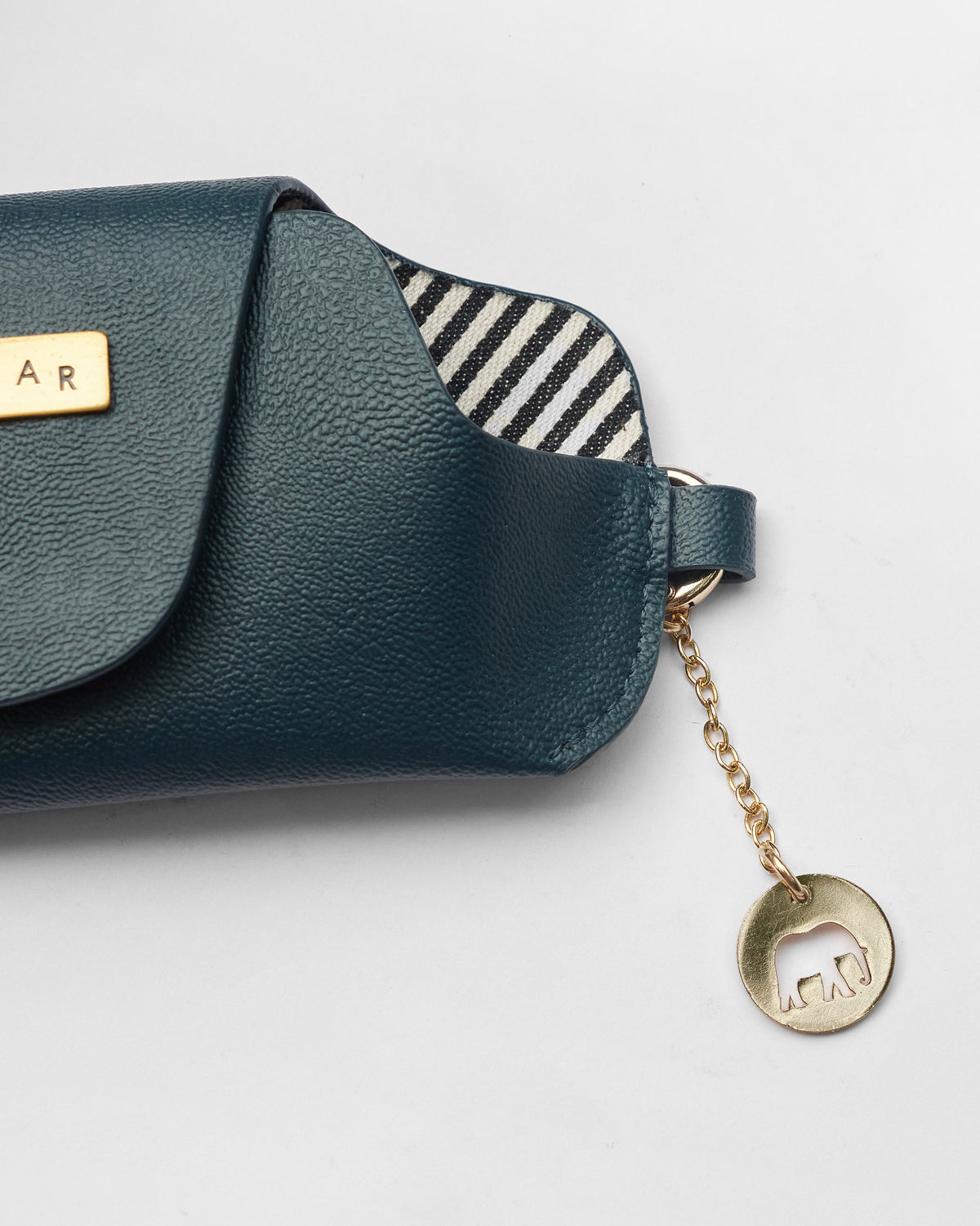 Close-up of a Tusker Gift Set leather pouch with a gold elephant charm.
