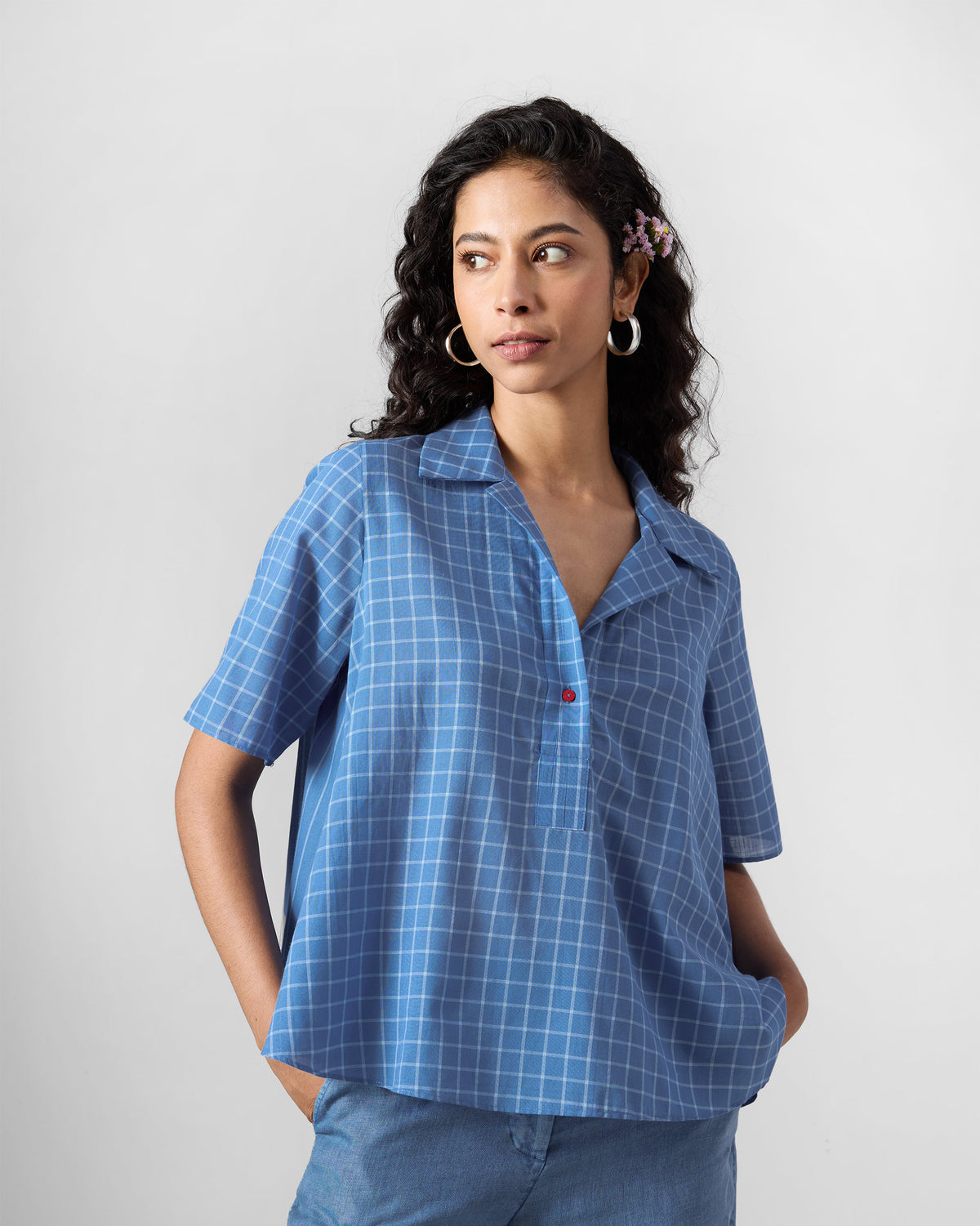 Person wearing a riverside blue Rann shirt with a red button.