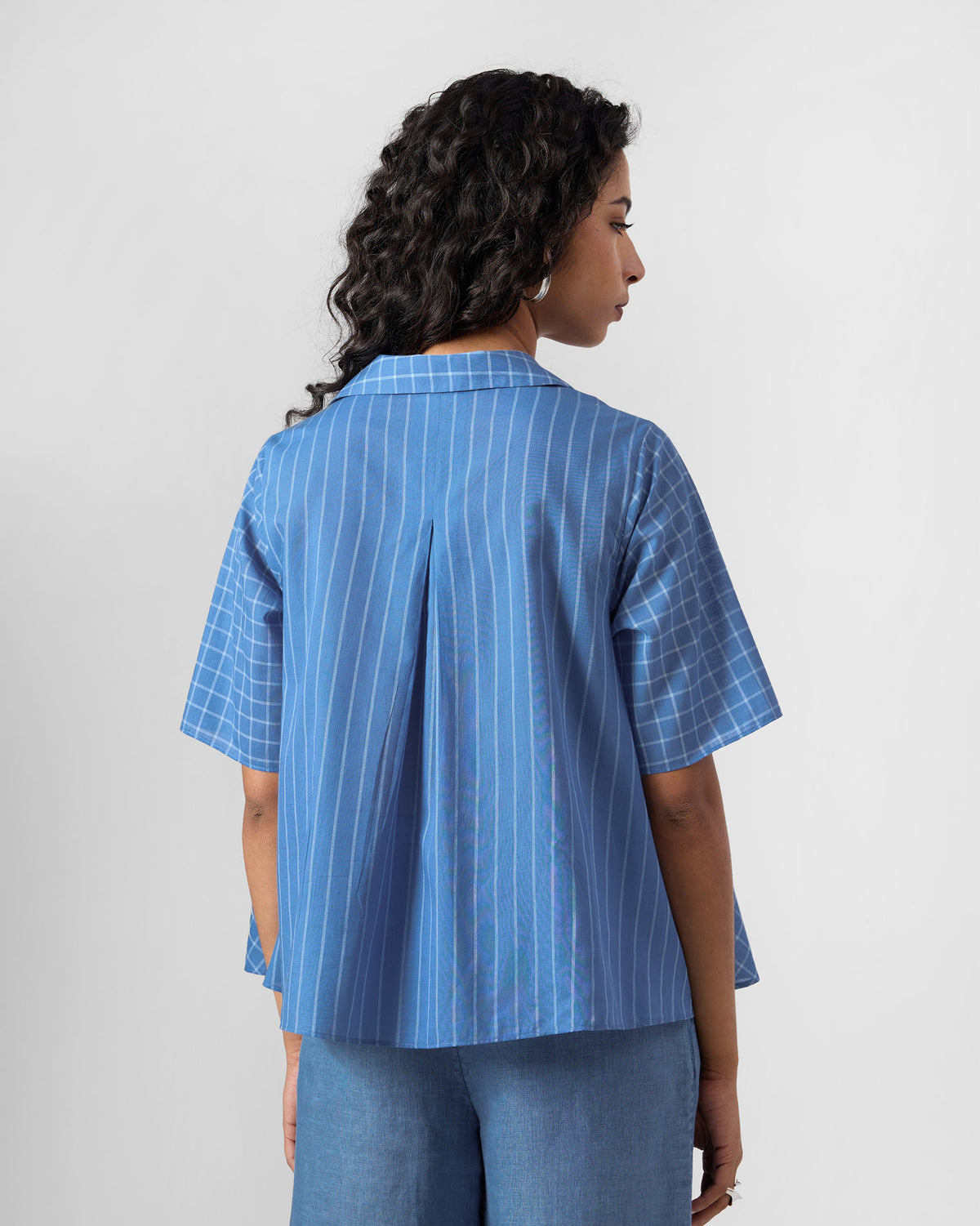 Back of a riverside blue Rann shirt with an inverted pleat.