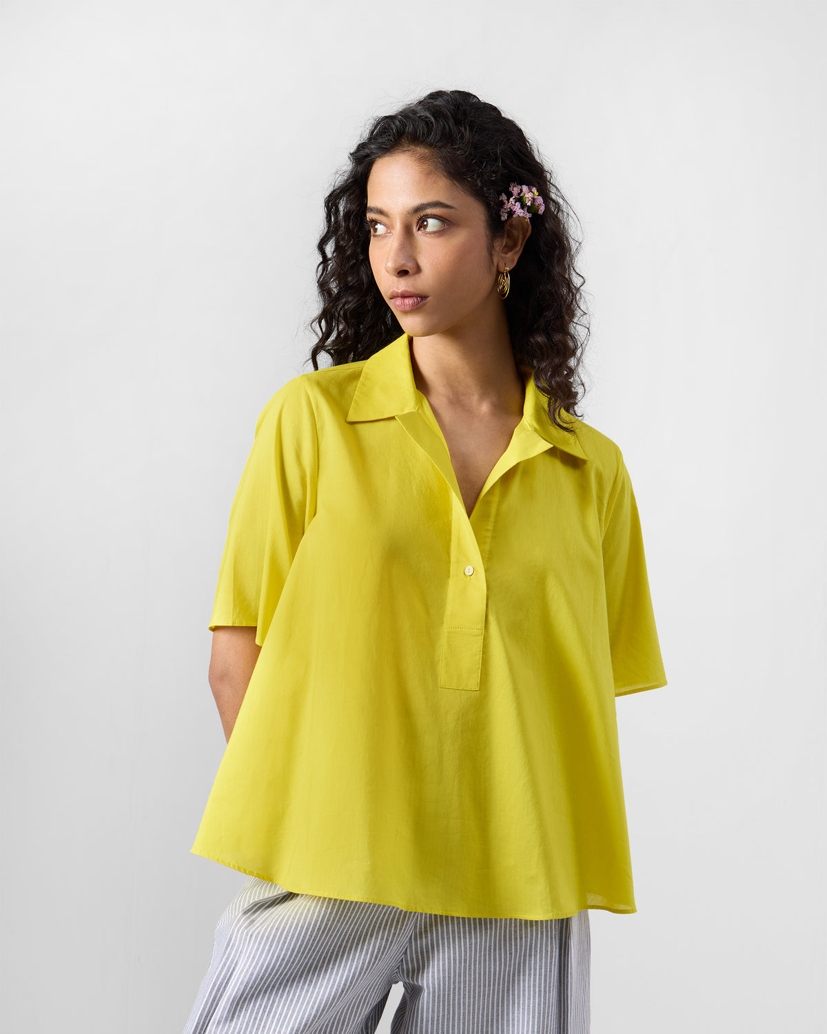 Person wearing a chartreuse Rann shirt with a short button placket.