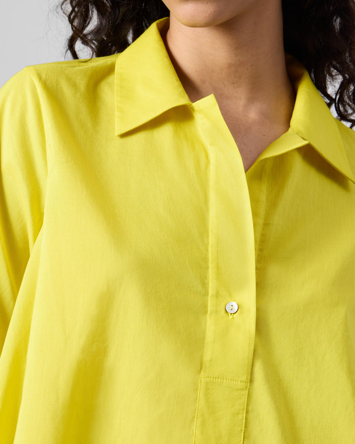 Close-up of the collar and button placket on a chartreuse Rann shirt.