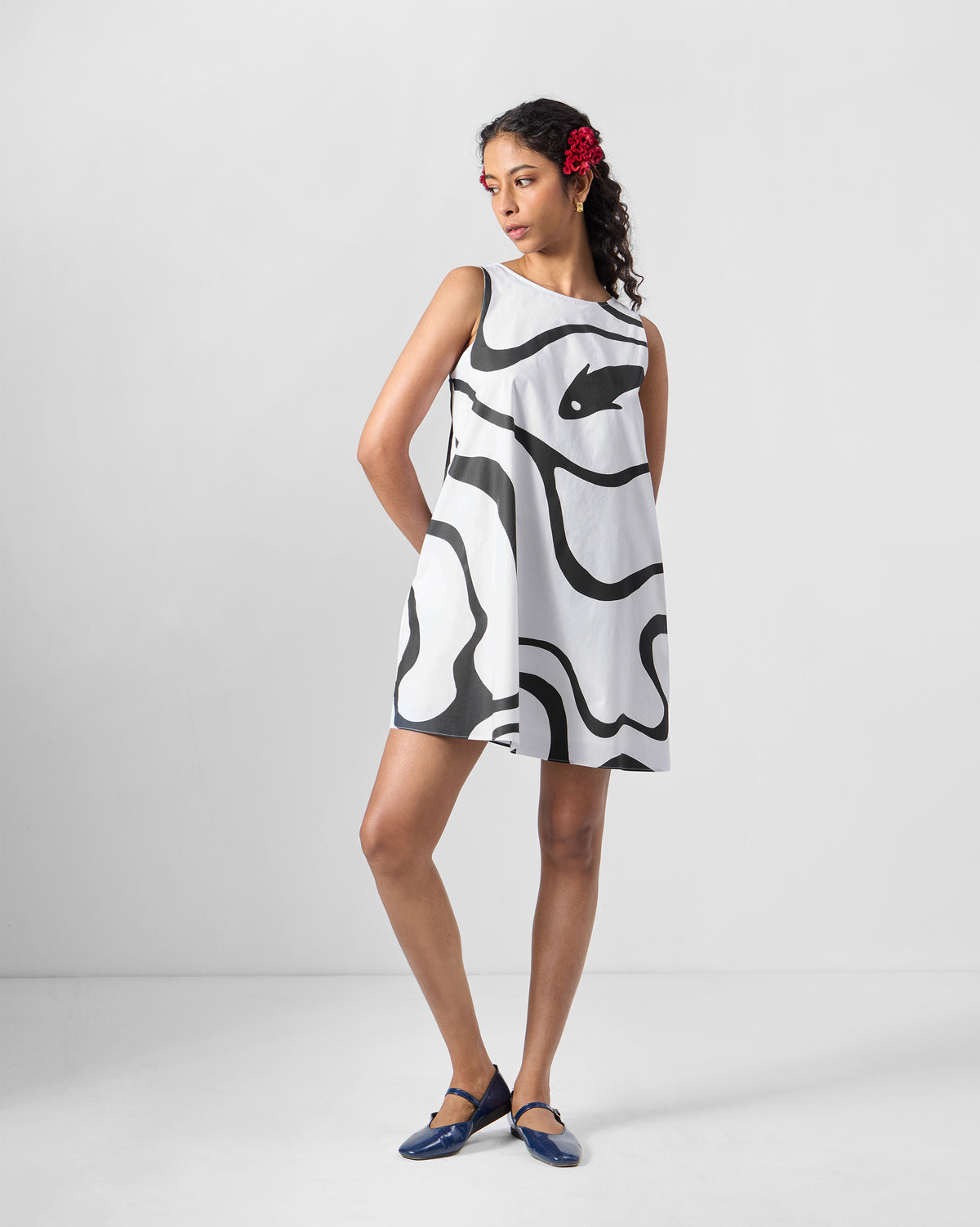 Person wearing a black printed short racerback dress with a wavy graphic print.