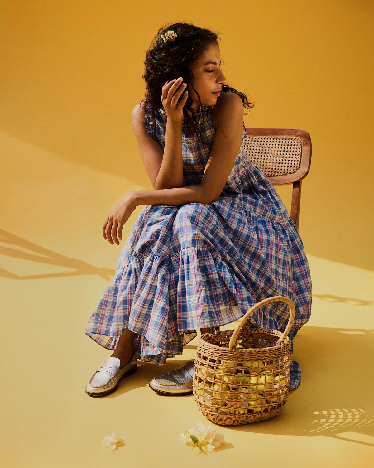 Person seated in a long blue checked Reah dress.