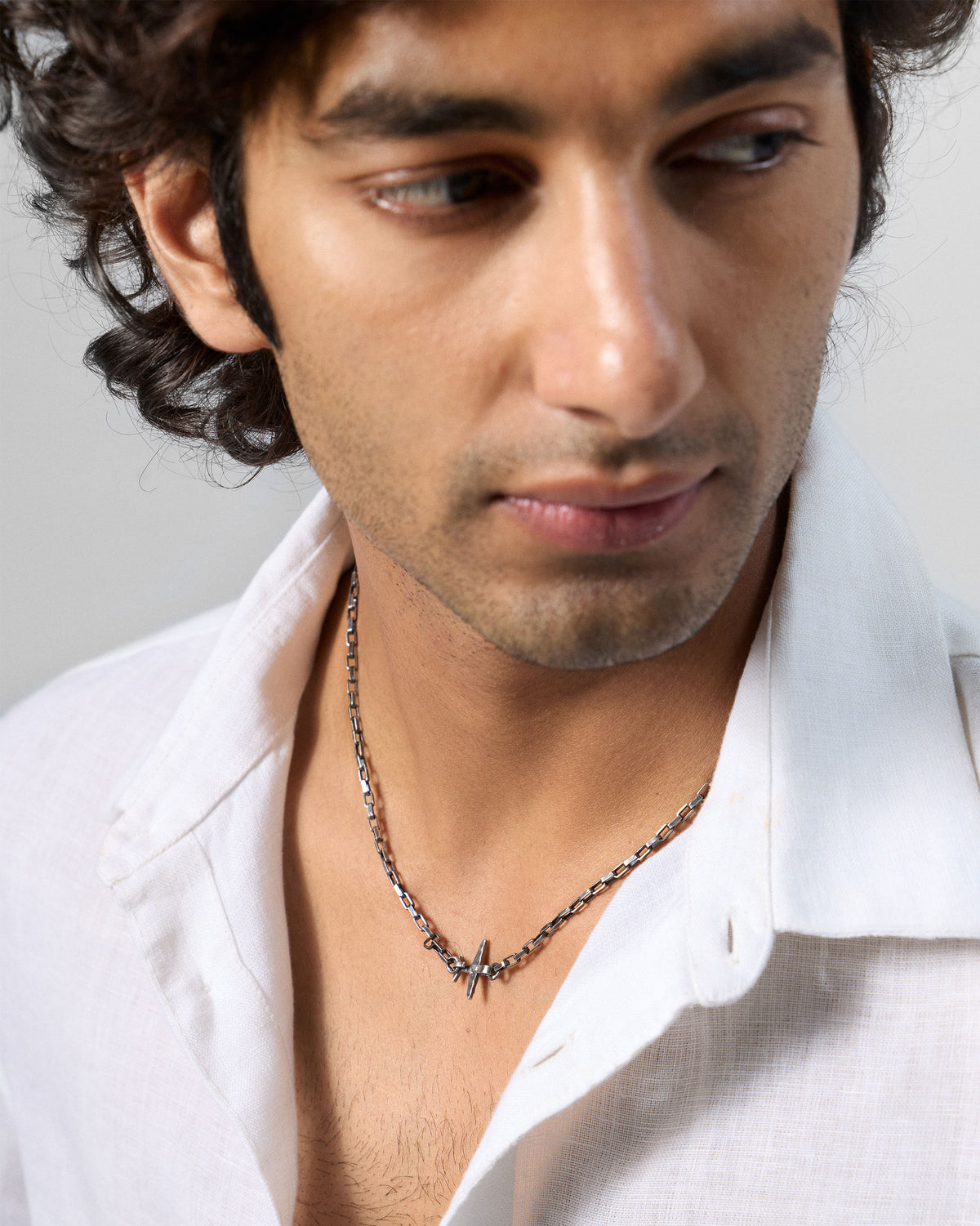 Person wearing a silver Flight Chain with a small airplane motif at the neck.