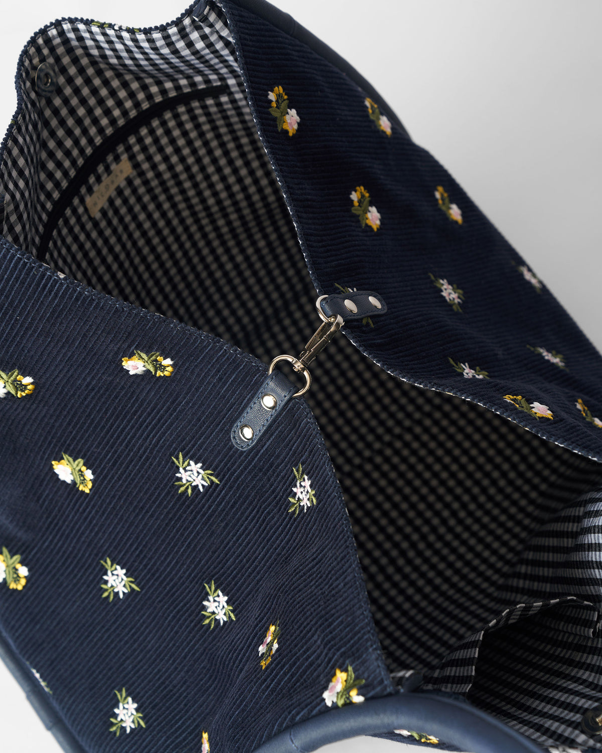 Close-up of the clasp closure inside a navy Ditsy bag.