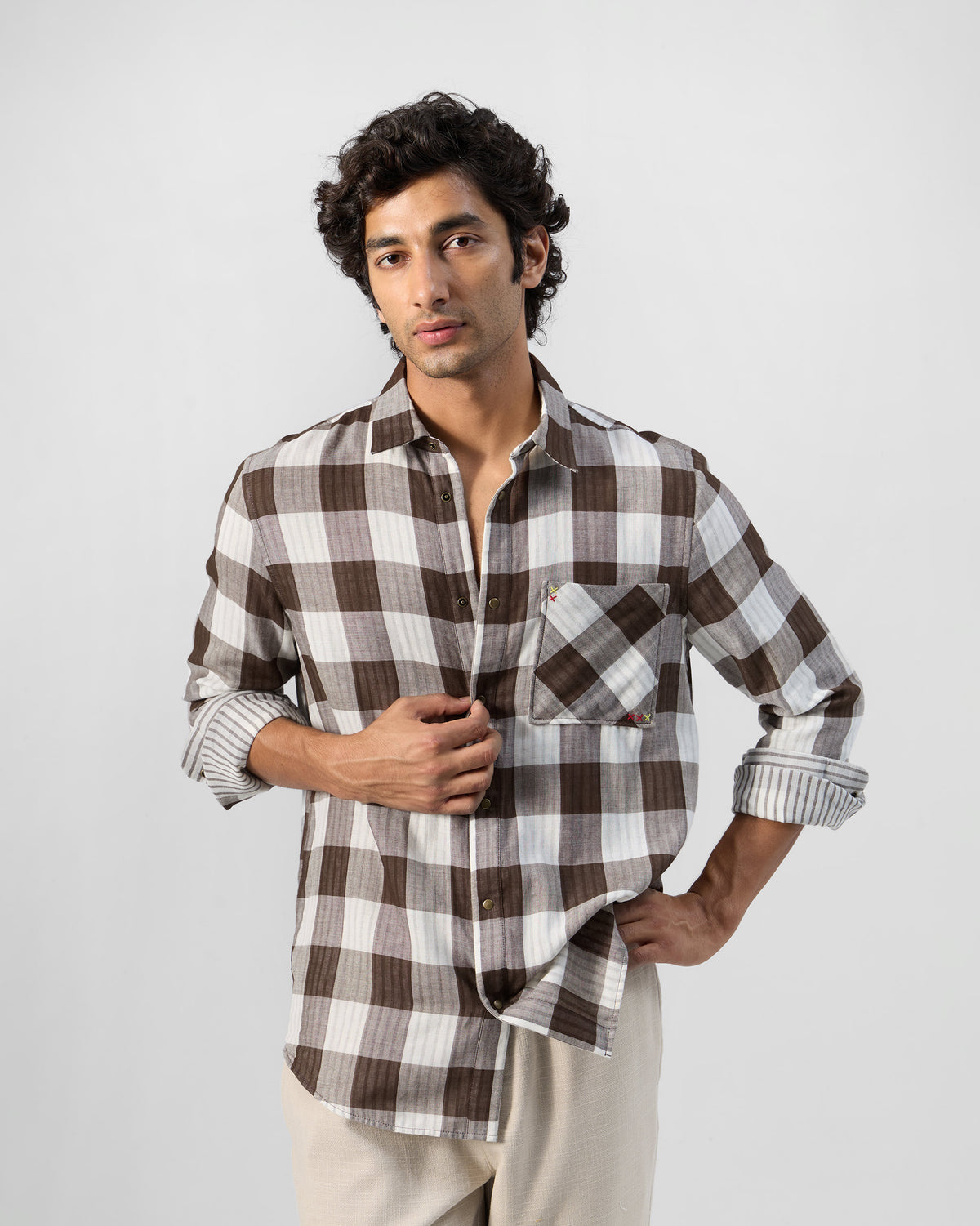 Person wearing a brown and white check Milaan shirt.