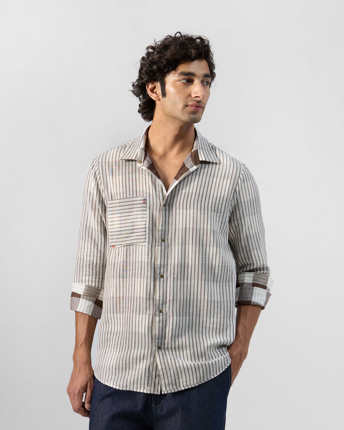 Person wearing a beige striped Milaan shirt on the reverse side.
