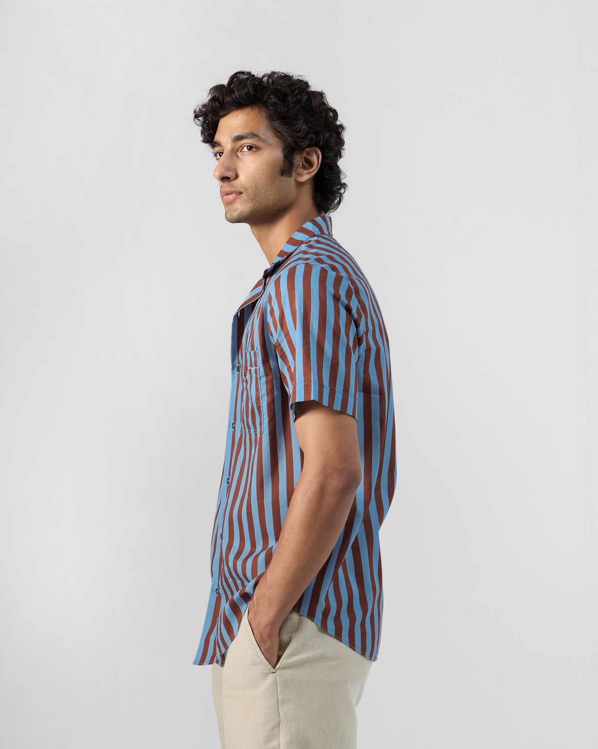 Side view of a blue and brown striped Mason shirt worn by a person.