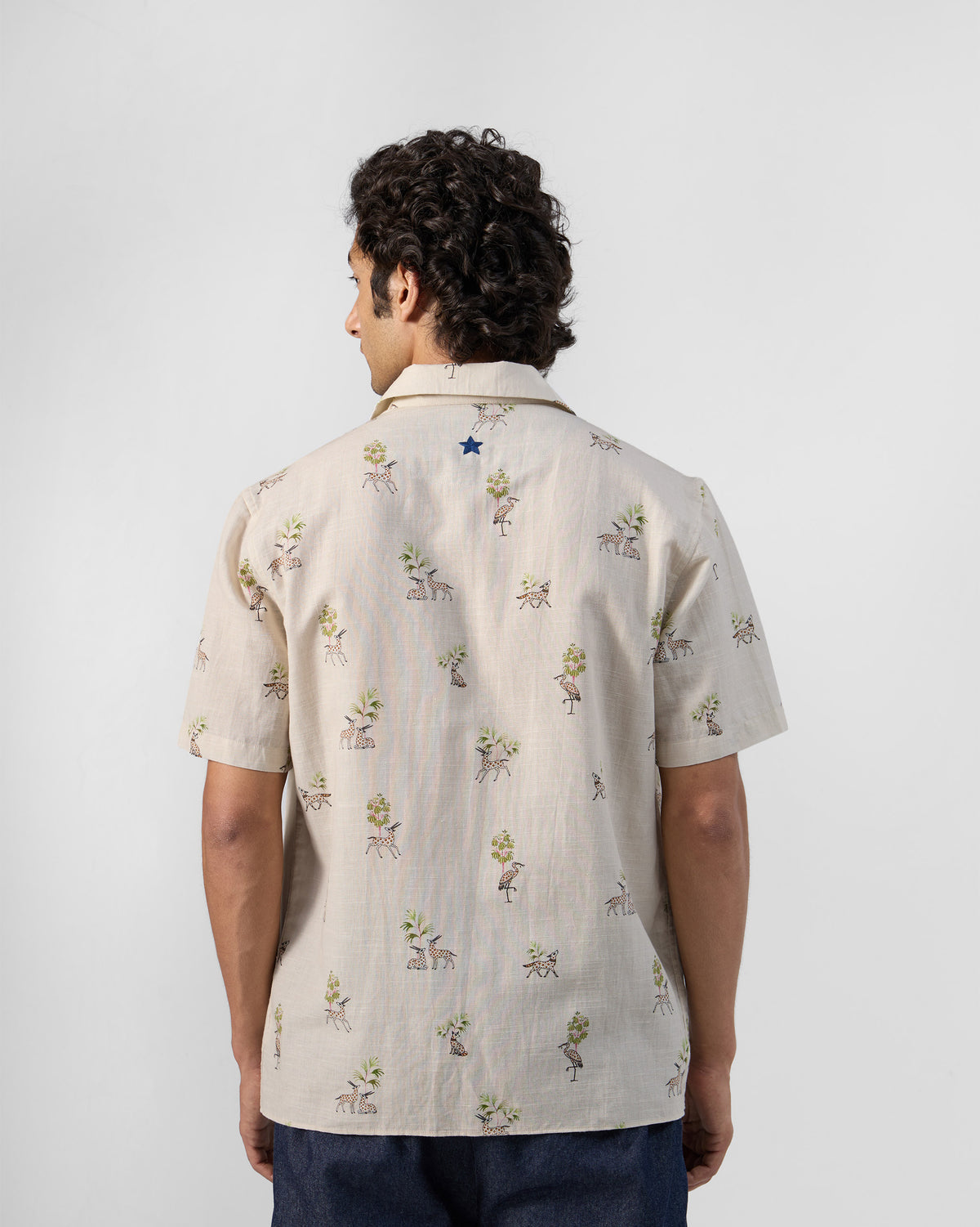 Back of a cream Bena shirt with a small blue star.