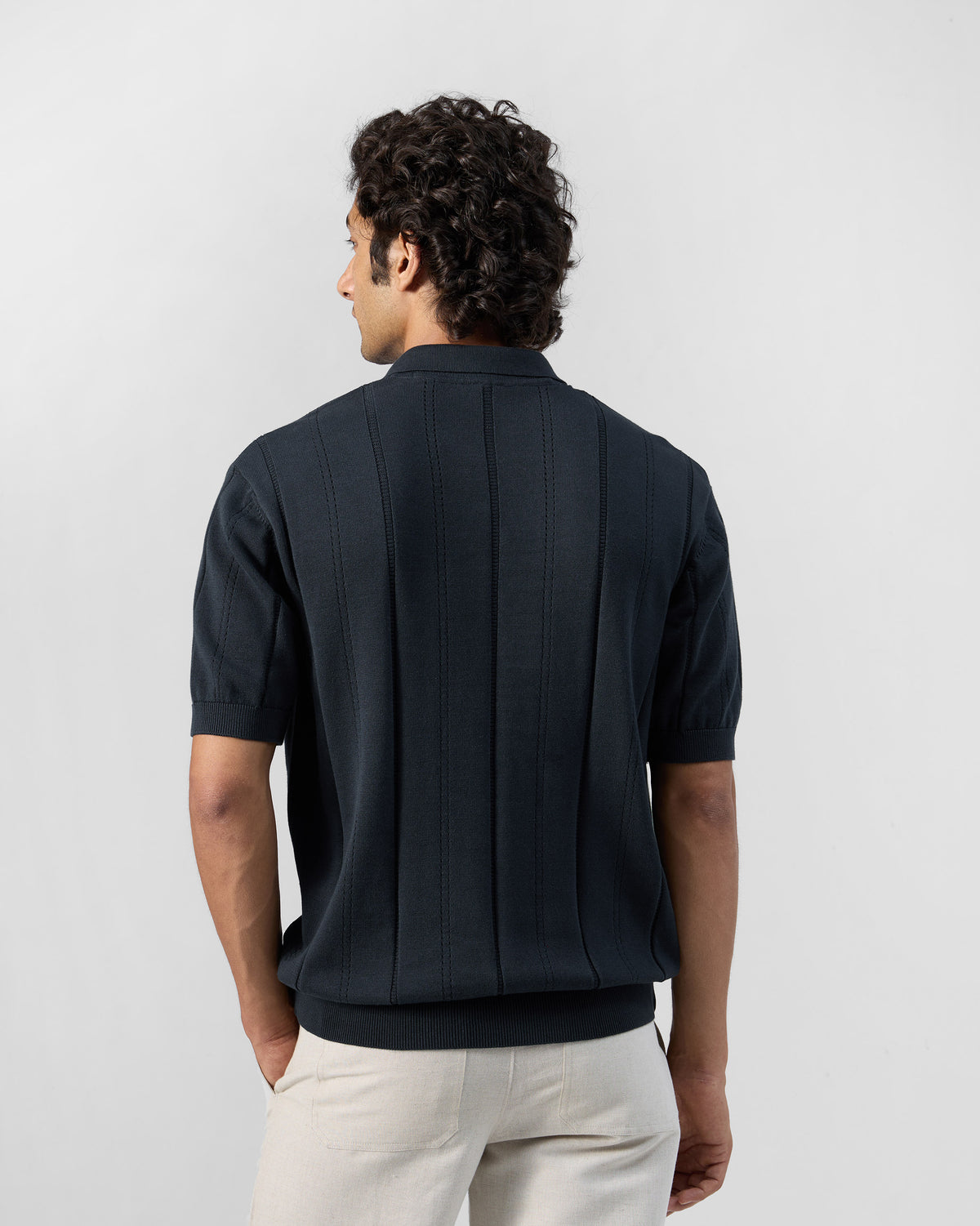 Back of a dark navy Midnight polo with a vertical ribbed knit.