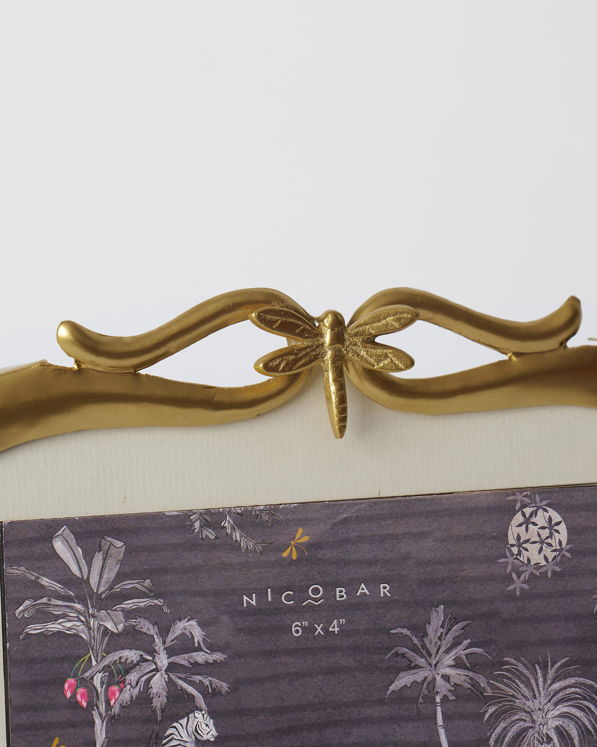 Close-up of the dragonfly crest on a gold Leap photo frame.