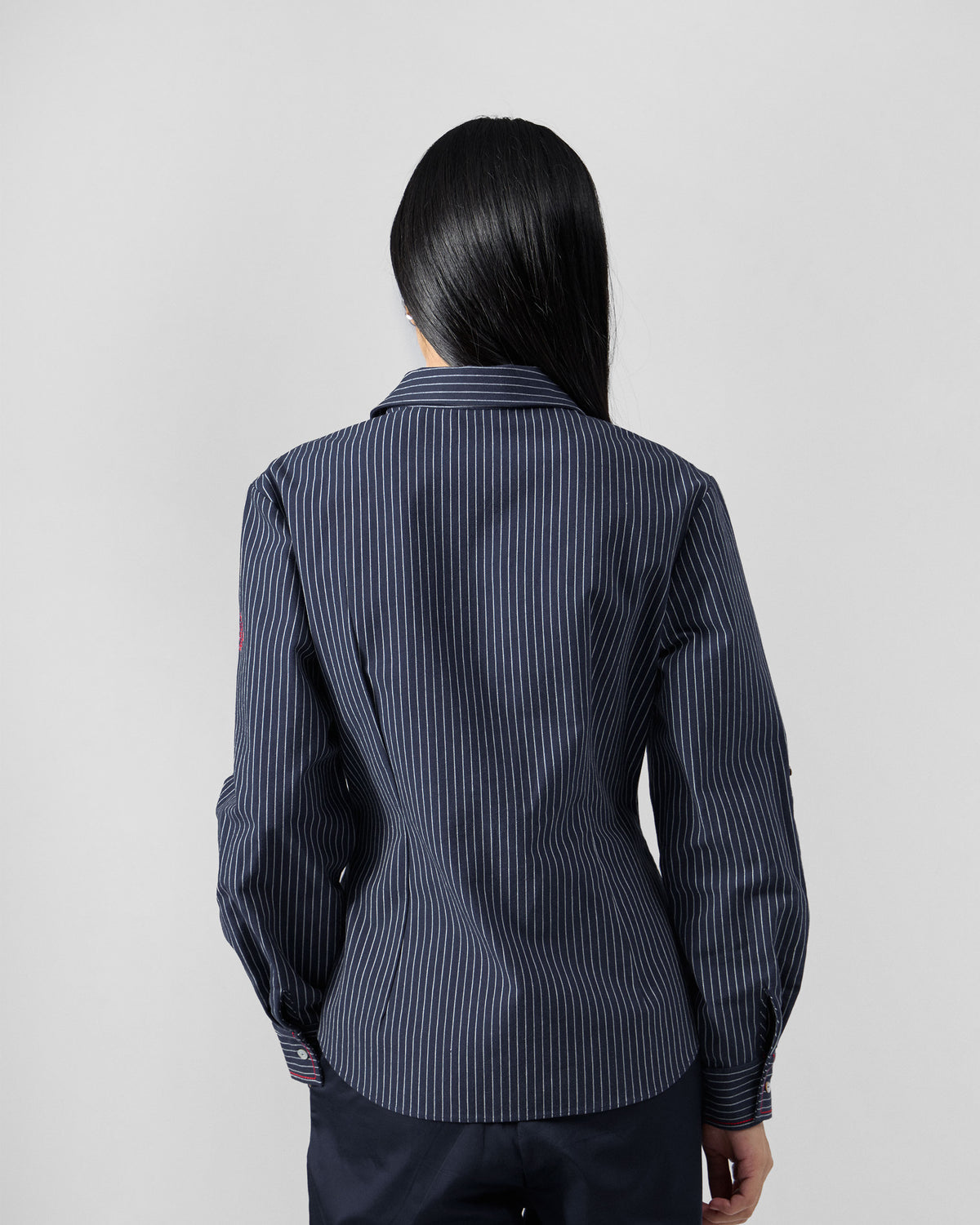 Back of a navy pinstripe Kalo shirt with a fitted waist.