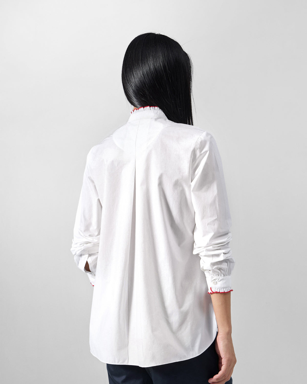 Back of a white Sora ruffle shirt with a center box pleat.